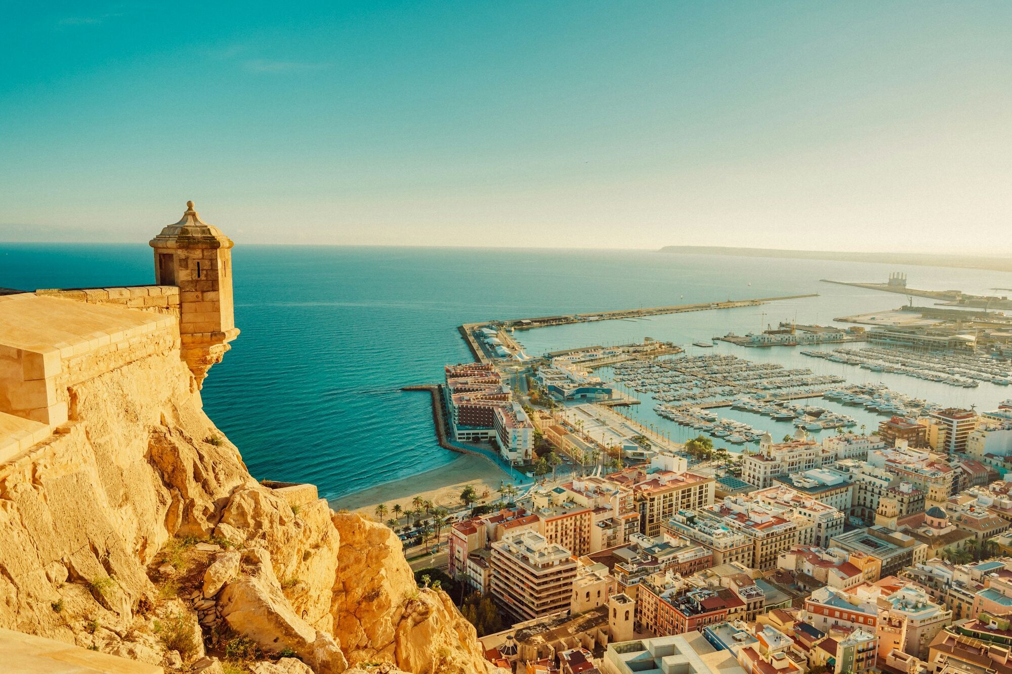 Coastal view of Alicante harbour and city skyline under clear summer skies