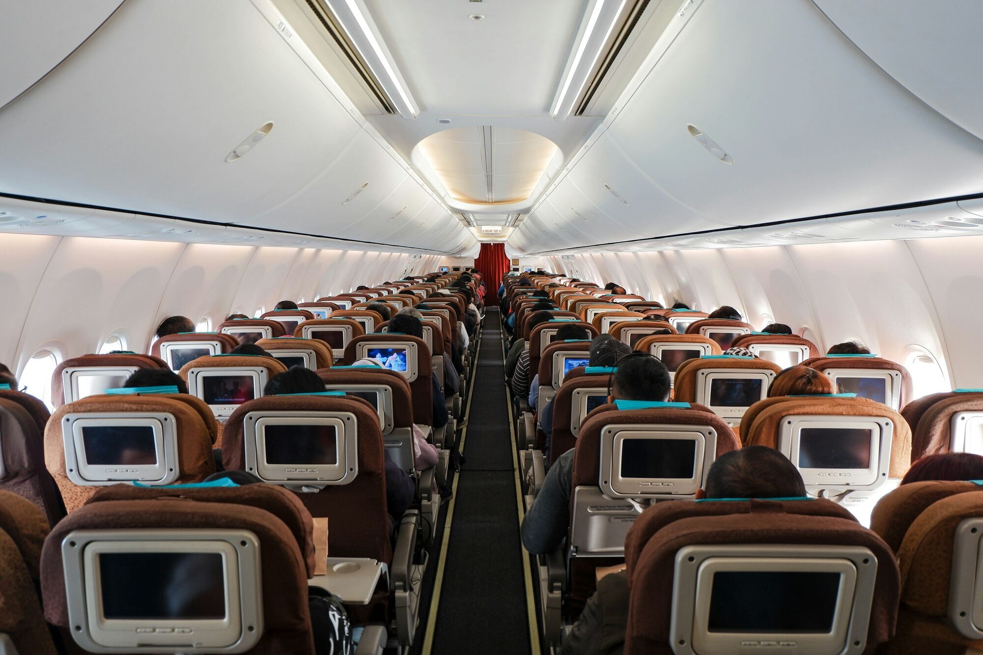 Economy class cabin filled with seated passengers during flight