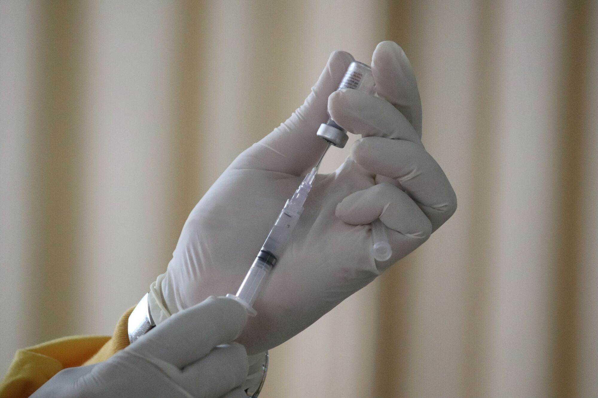 Medical professional preparing a vaccine injection with a syringe