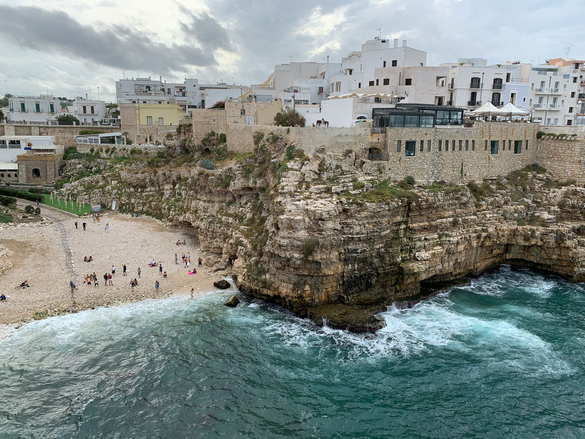 Coastal town with white buildings and rocky cliffs above the sea