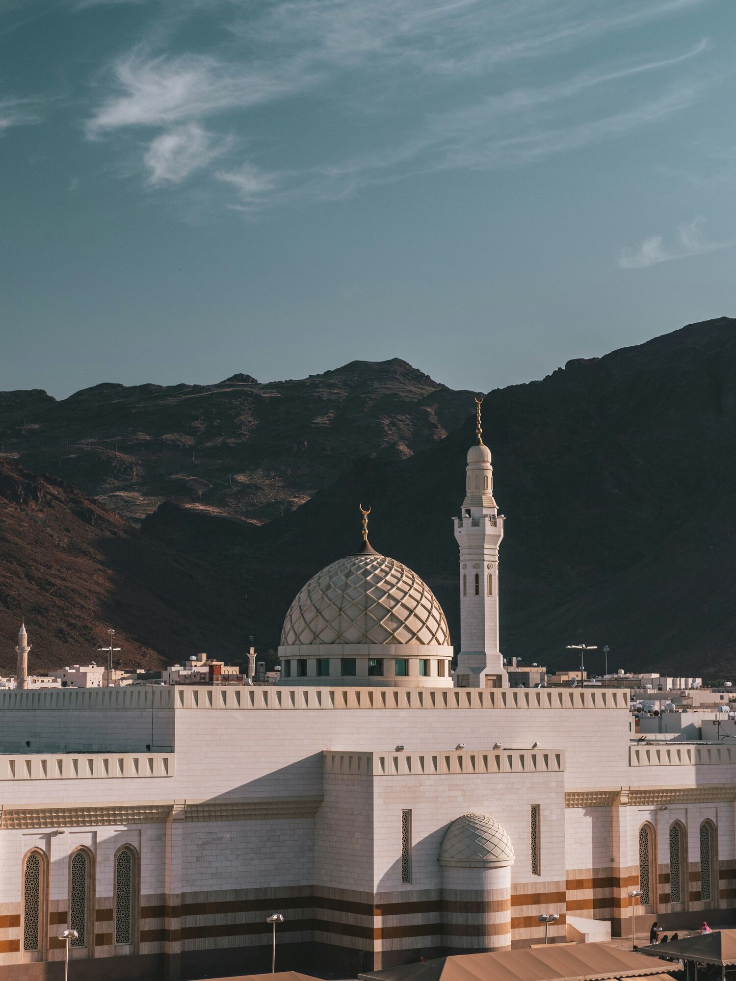 Mosque with dome and minaret set against mountains in Medina