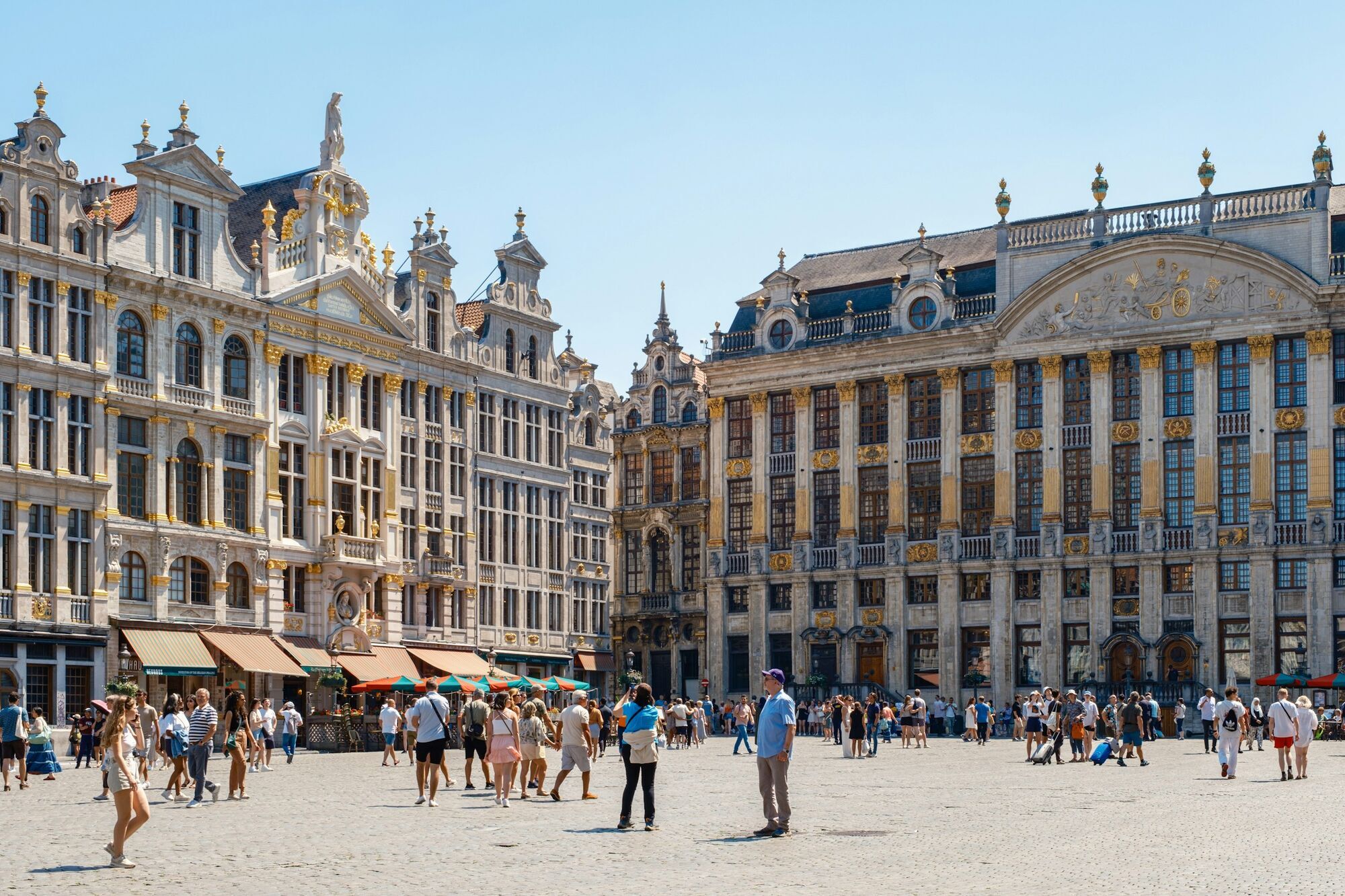 Tourists walking across Grand Place square in Brussels