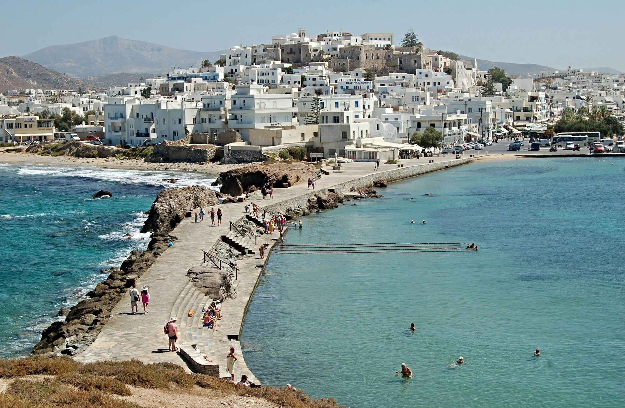 Greek island coastal town with white buildings and seaside promenade