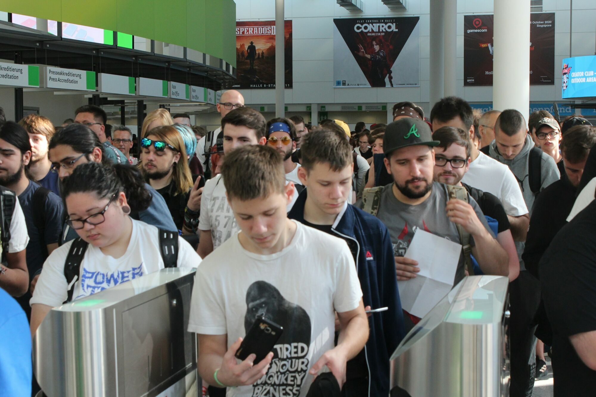 Crowd of travellers queuing at airport border control gates