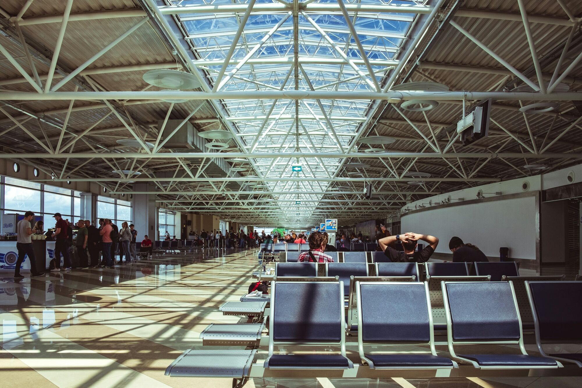 Passengers waiting inside airport departure hall