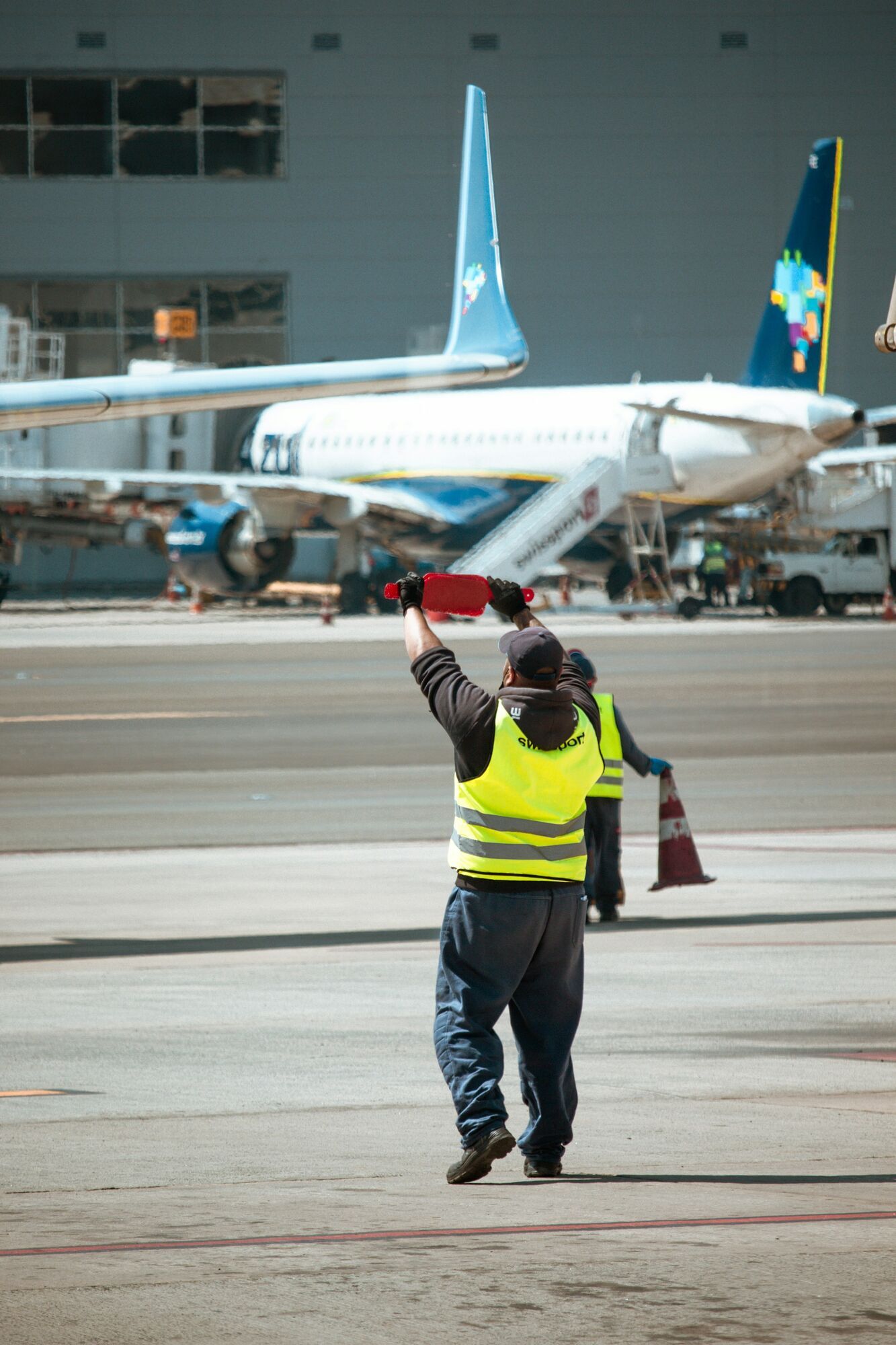 Airport ground staff directing aircraft on apron during operations