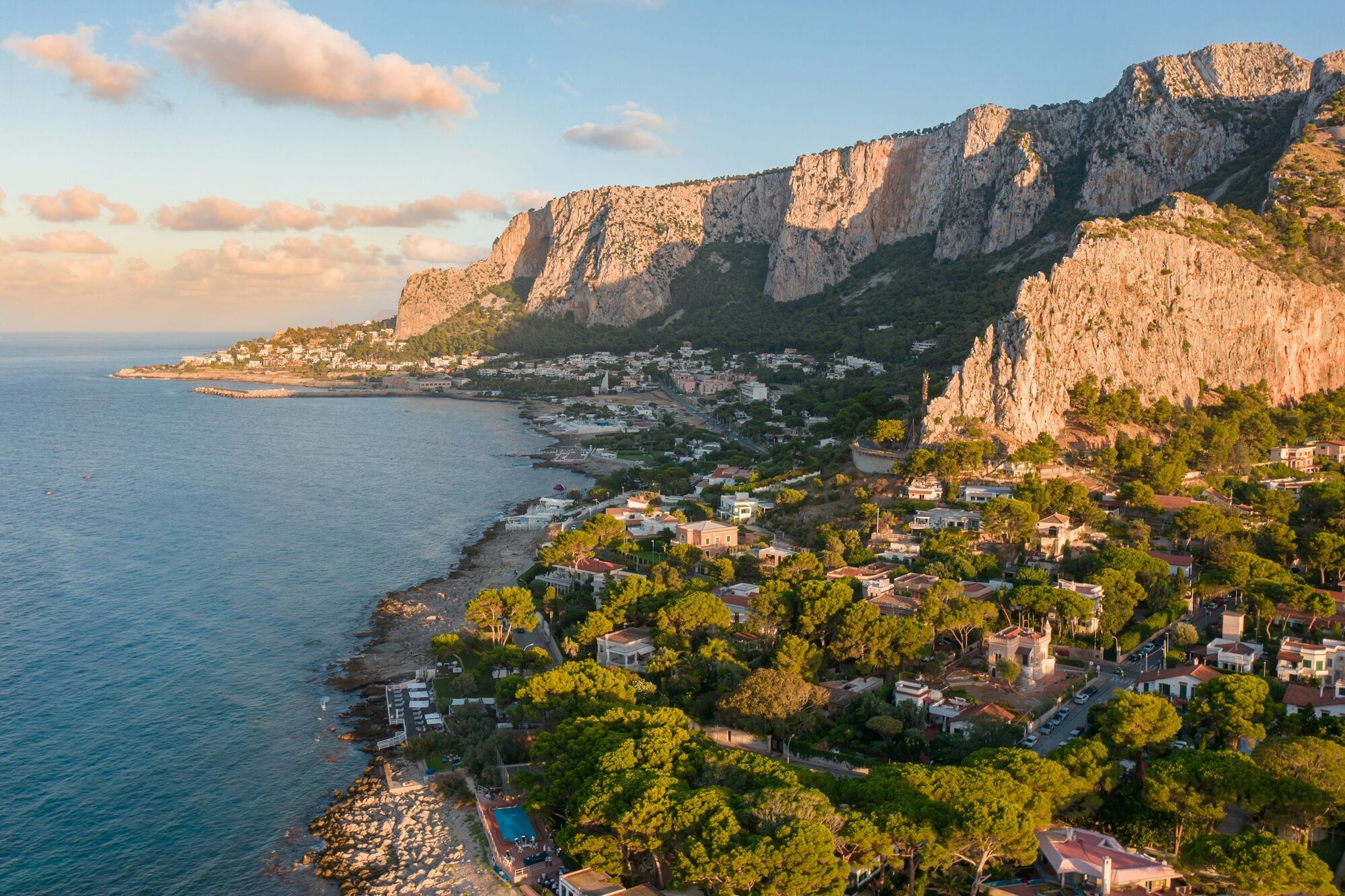 Coastal town below limestone cliffs at sunset
