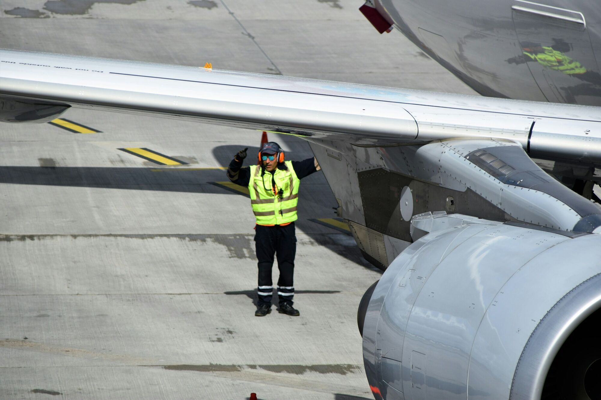 Ground staff guiding aircraft on active runway