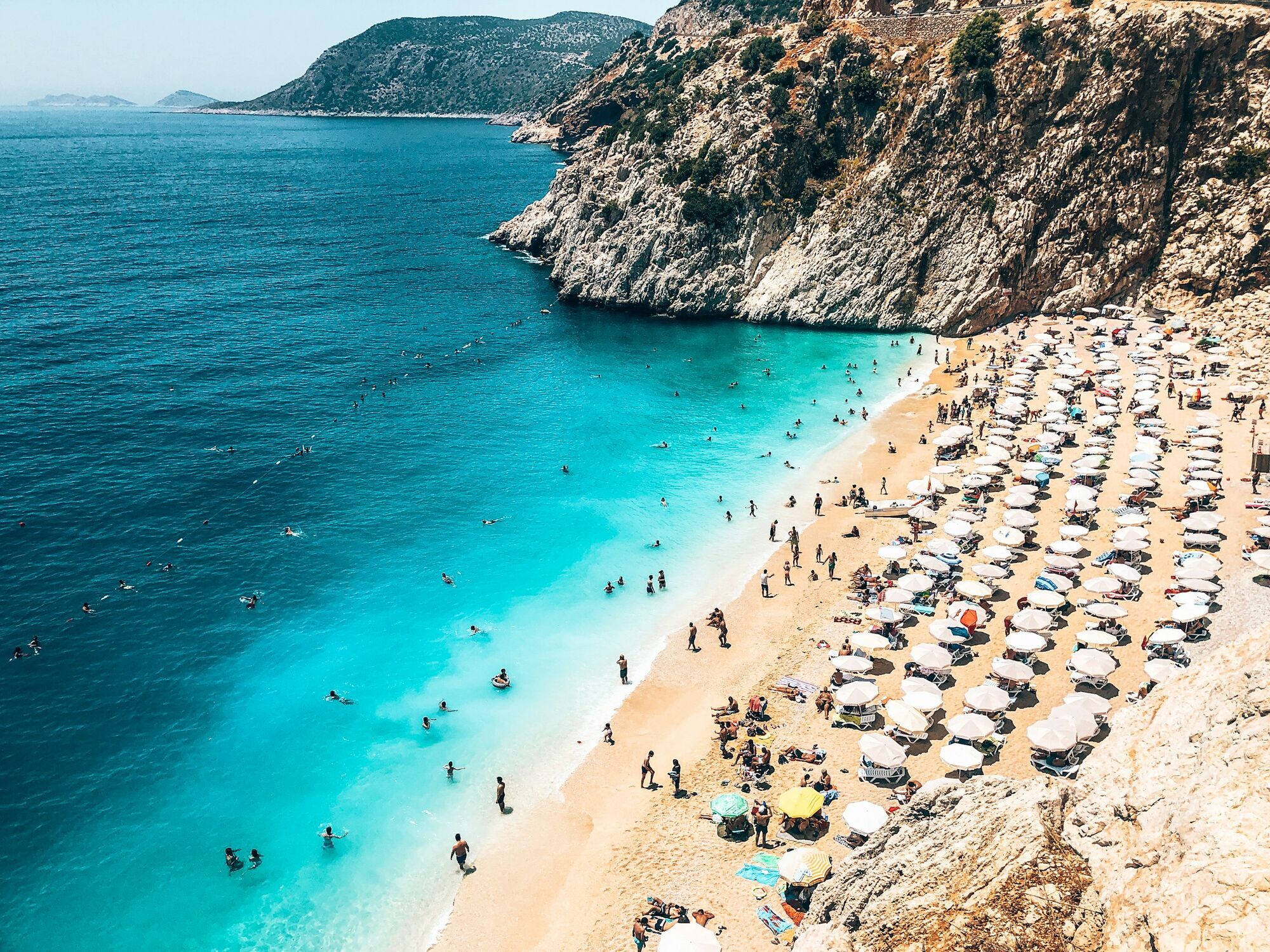 Busy beach with turquoise water and umbrellas on Turkey’s Mediterranean coast