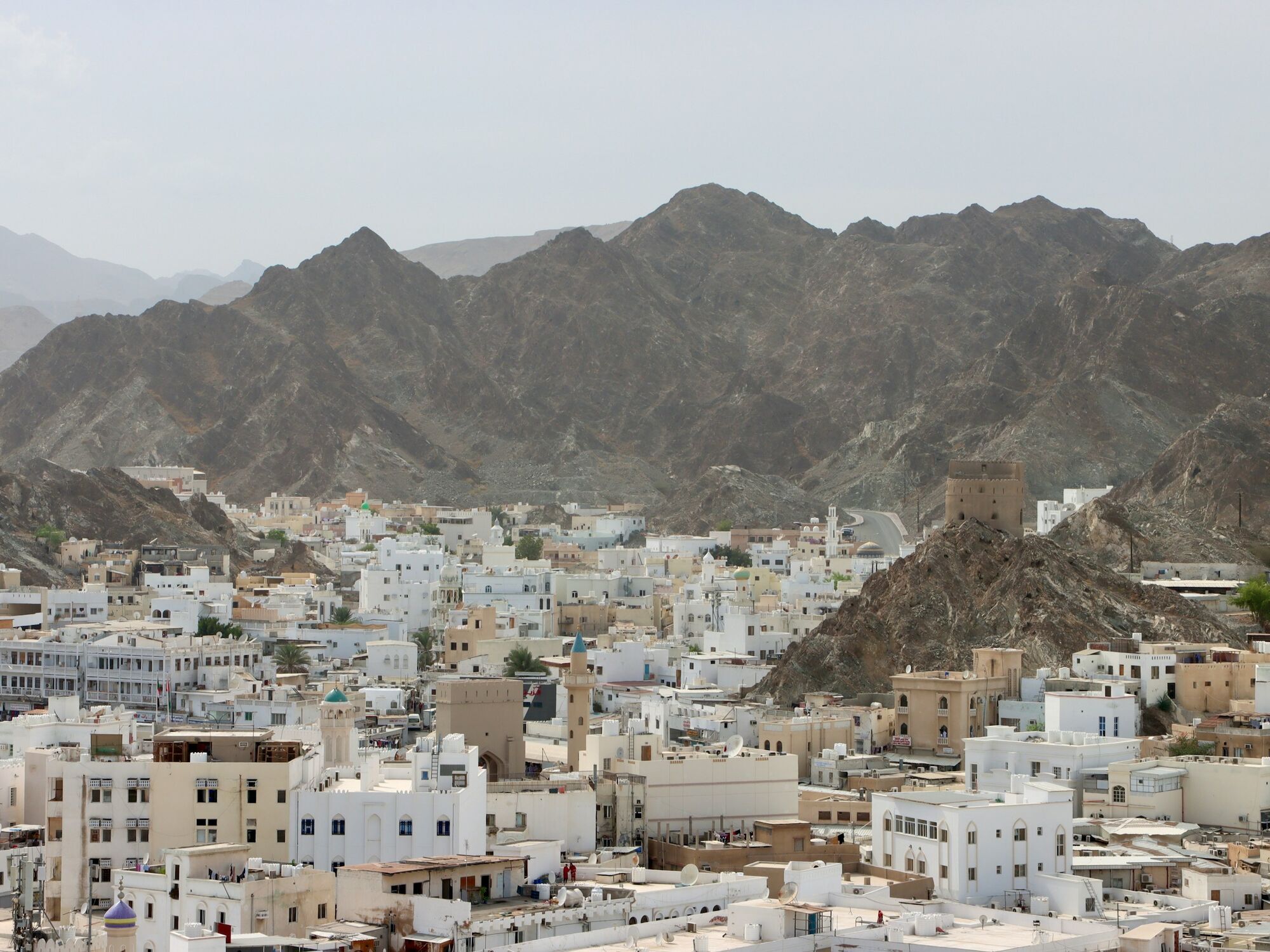 View of Muscat city with mountains and white buildings