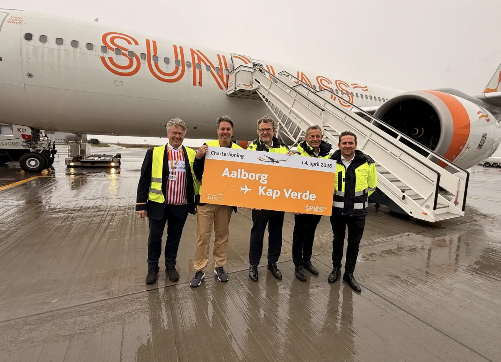 Sunclass Airlines aircraft and team holding Aalborg–Cape Verde route sign at airport