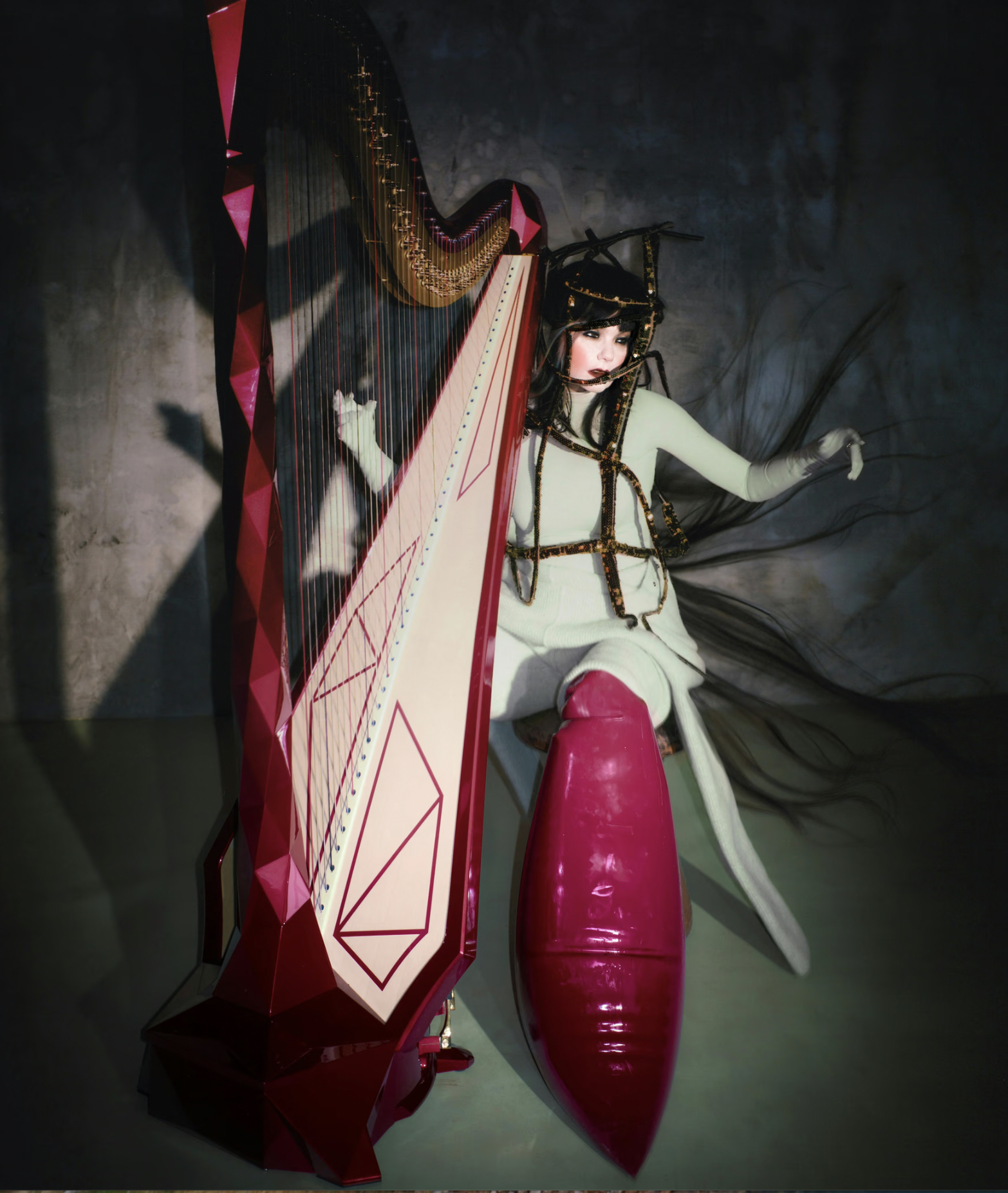 Björk performing with harp in artistic stage setting