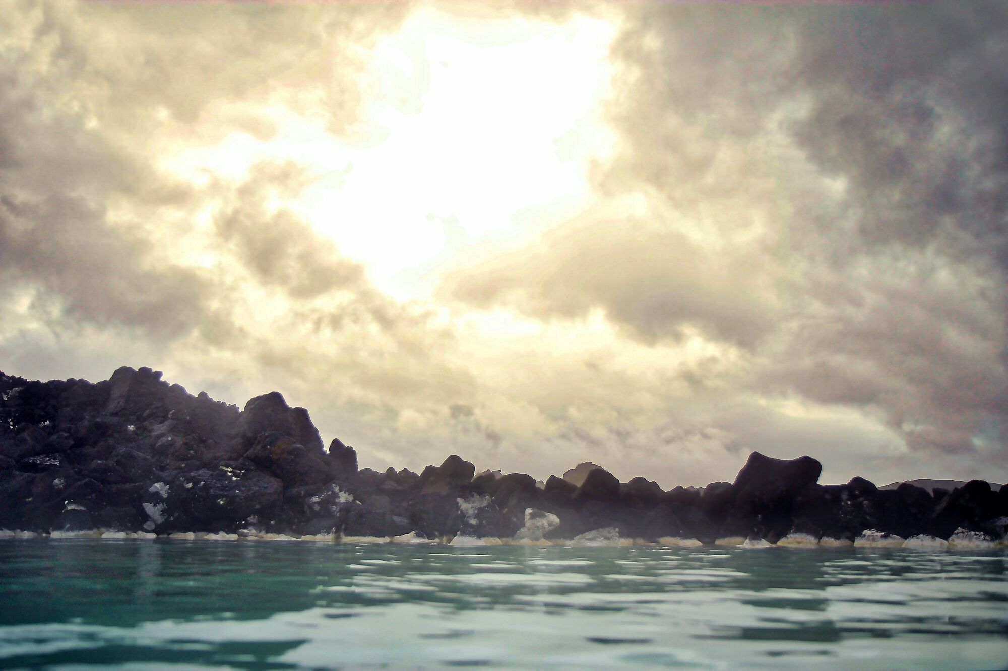 Geothermal mineral spring pool surrounded by volcanic rocks