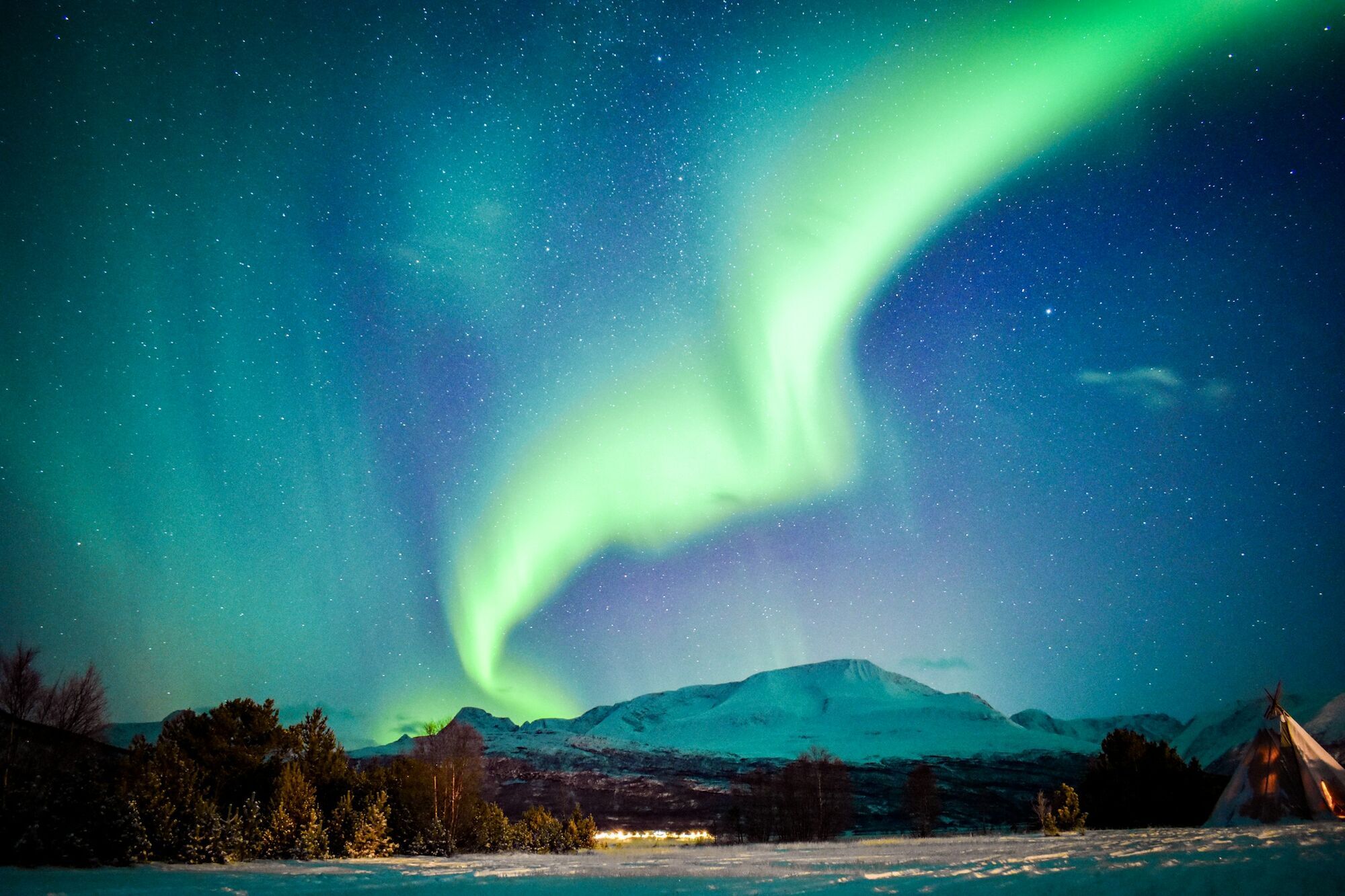 Northern lights over snowy mountains in northern Norway