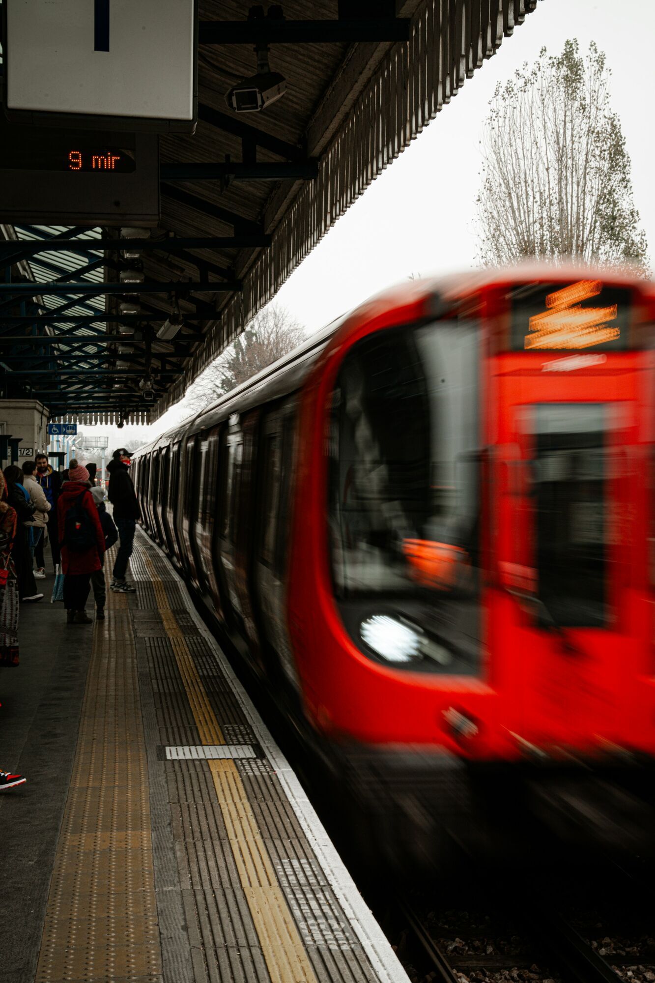 Modern train arriving at busy railway platform