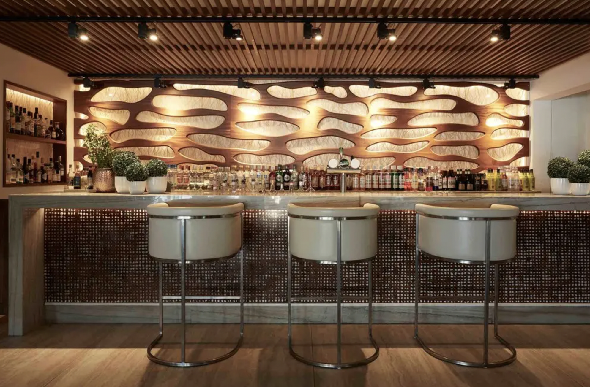 Resort bar with stools and backlit shelves of drinks in Cyprus hotel