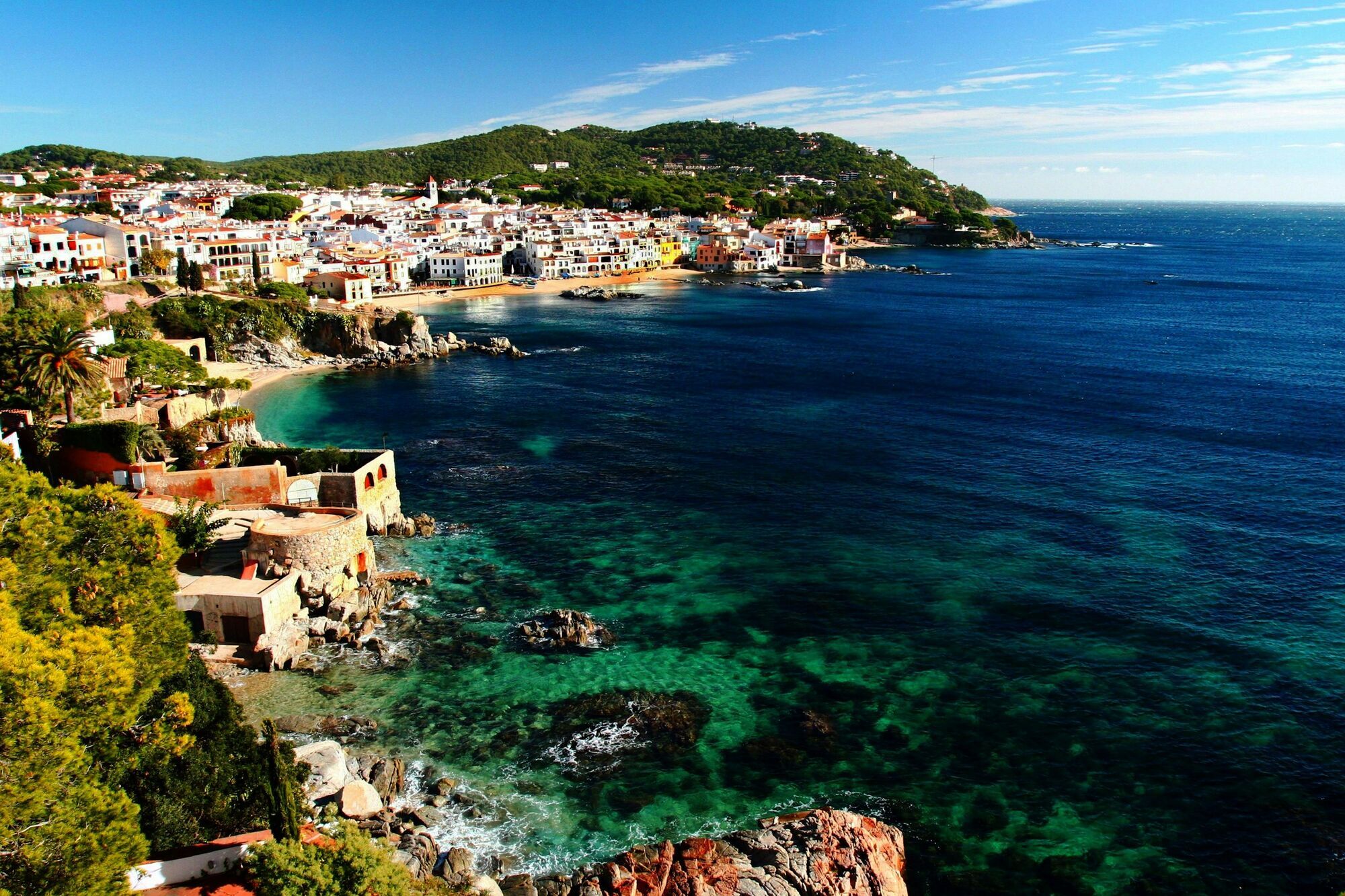 Coastal town on Costa Brava with clear turquoise water and hillside houses
