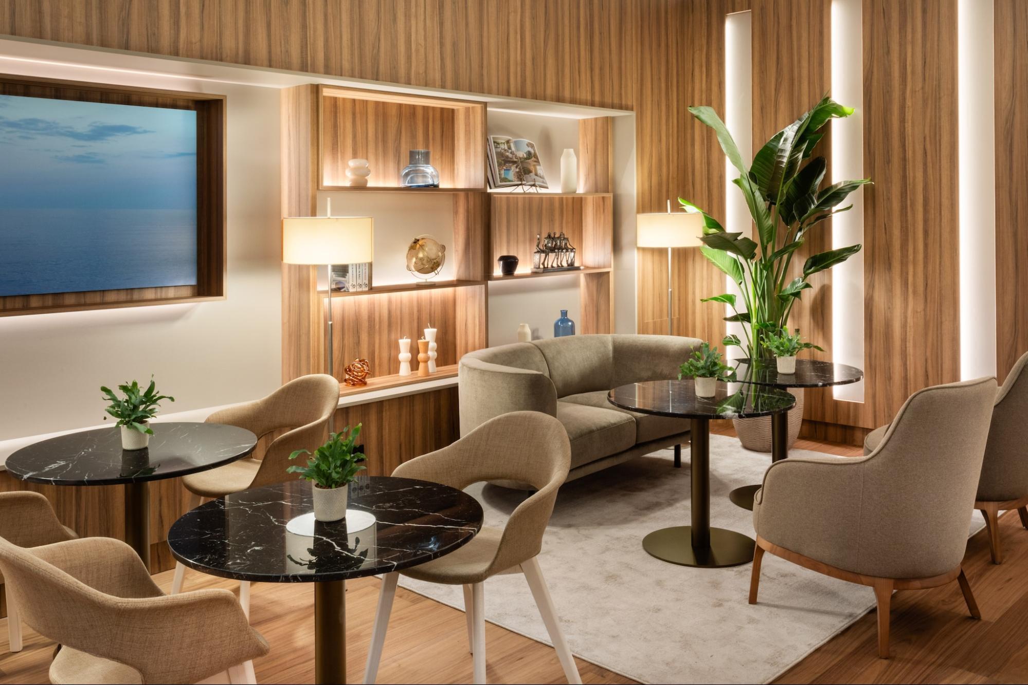 Hotel lounge area with seating, wooden shelves and soft lighting