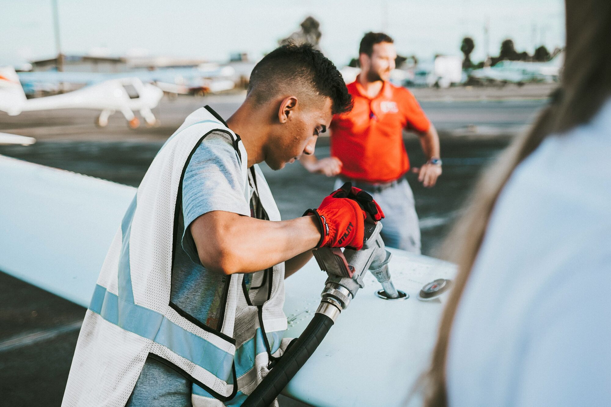 Ground crew refuelling aircraft on airport apron