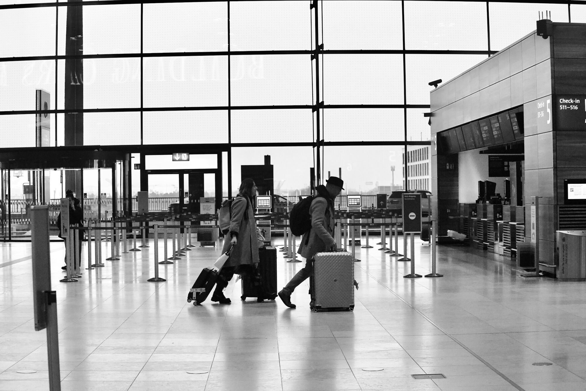 Travellers with luggage walking through airport check-in area