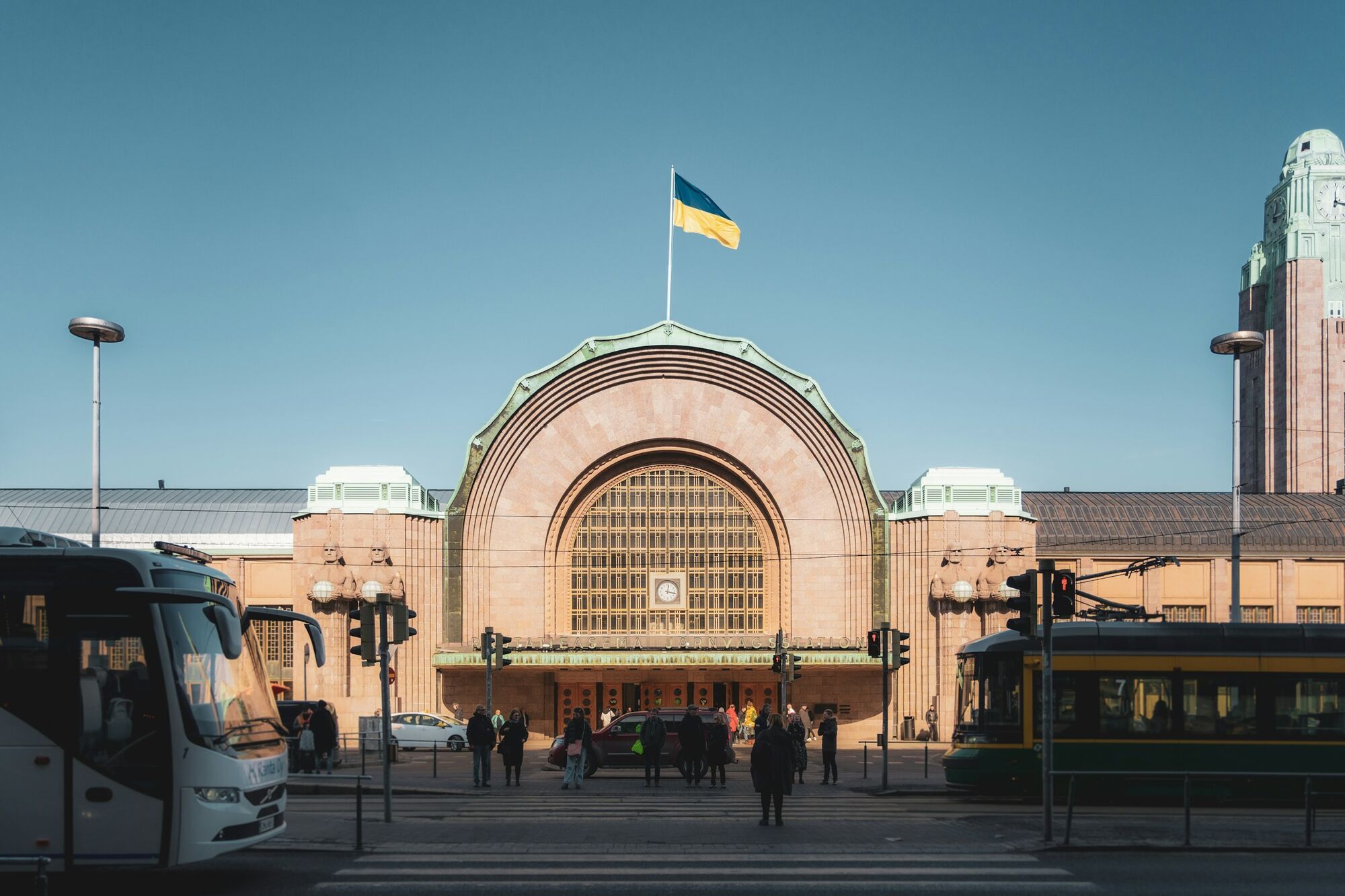 Helsinki Central Railway Station with trams and pedestrians outside