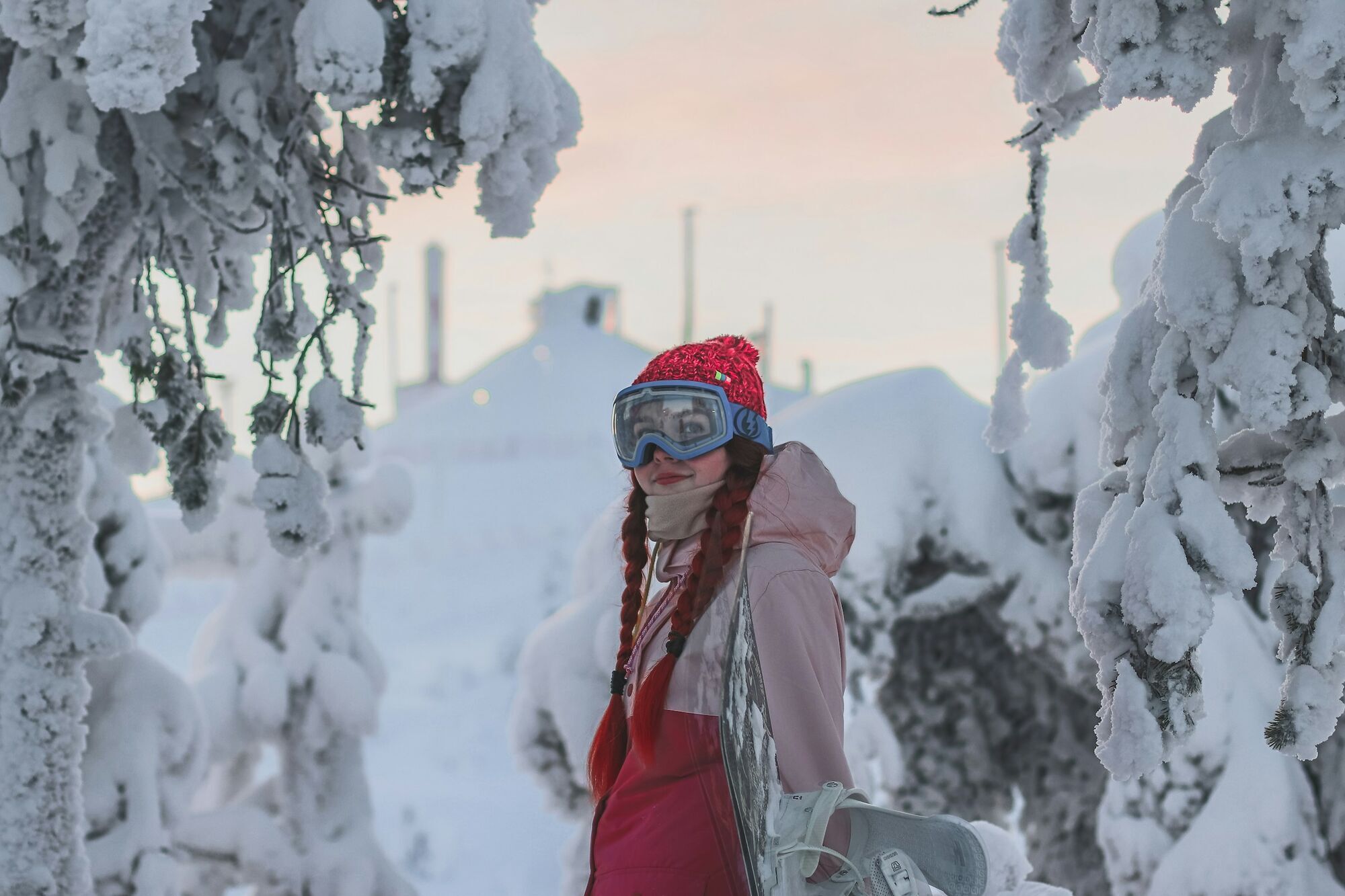 Person with snowboard in snowy forest landscape in Northern Finland