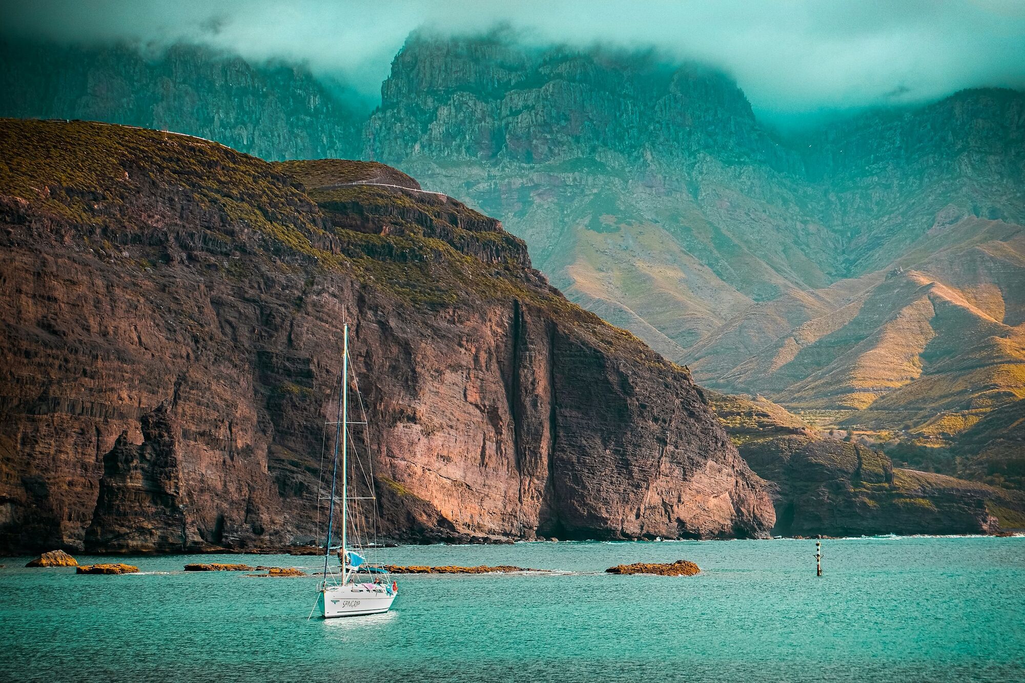 Rocky coastline and ocean view in Gran Canaria with mountains in background