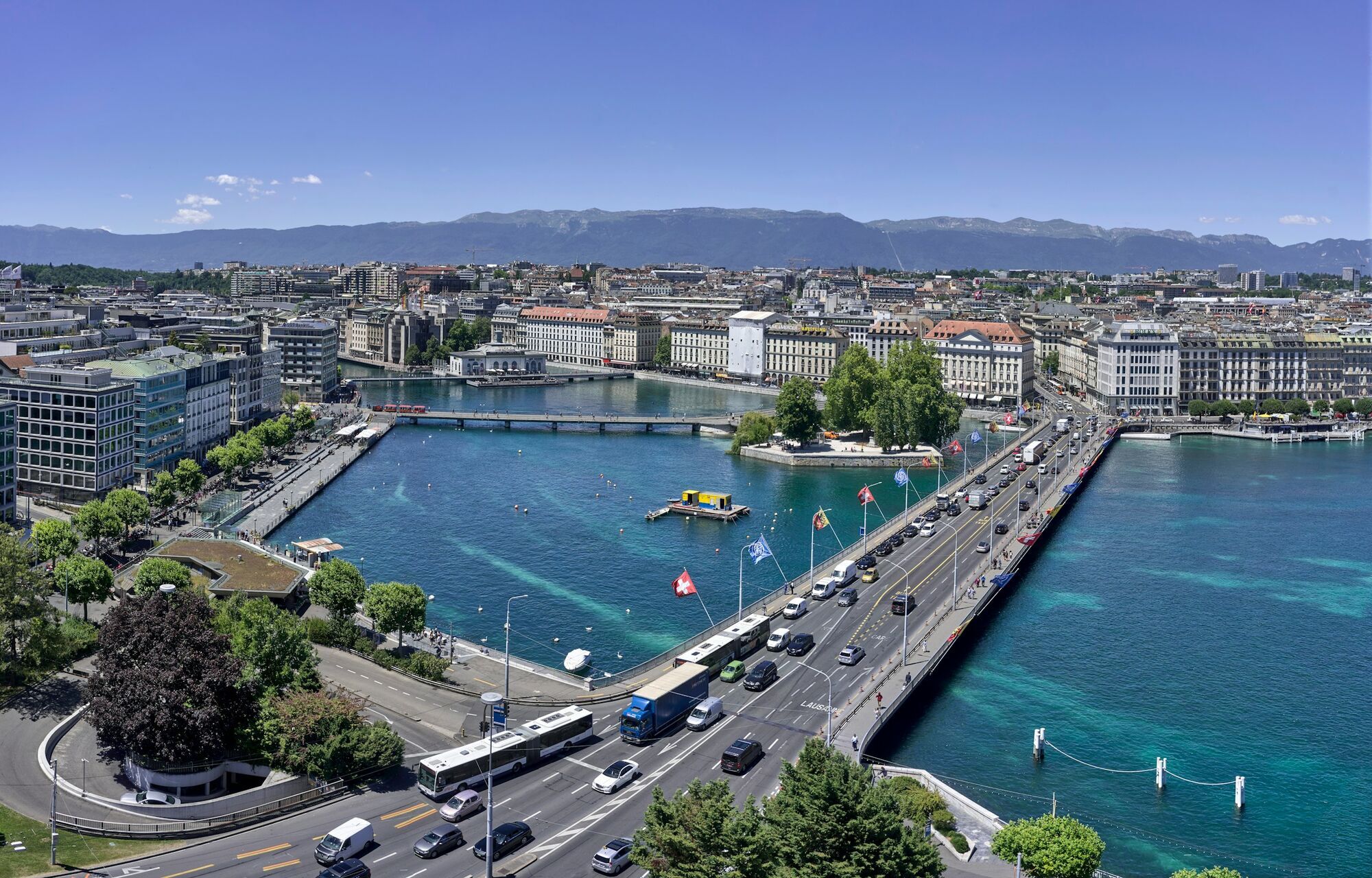 Geneva cityscape with lake and bridge, Alpine backdrop