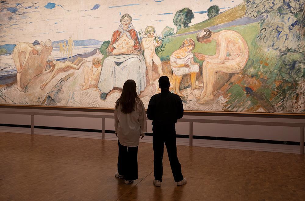 Visitors viewing large painting inside Munch museum