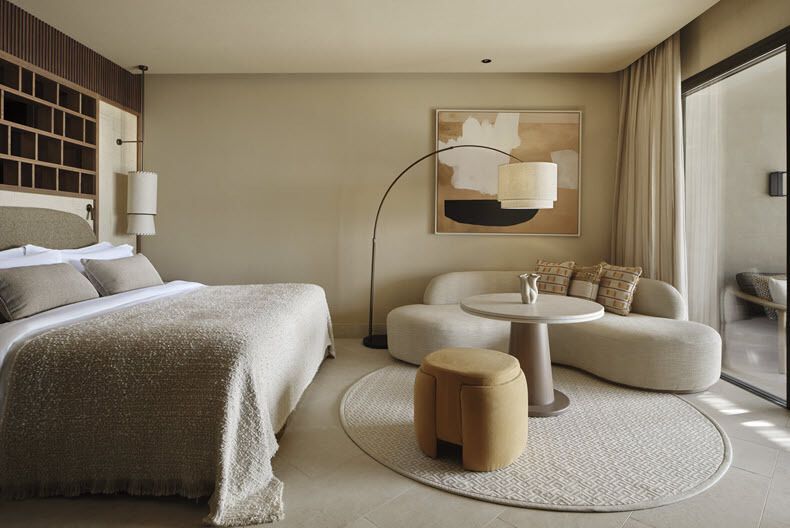 Modern hotel room with neutral tones and seating area