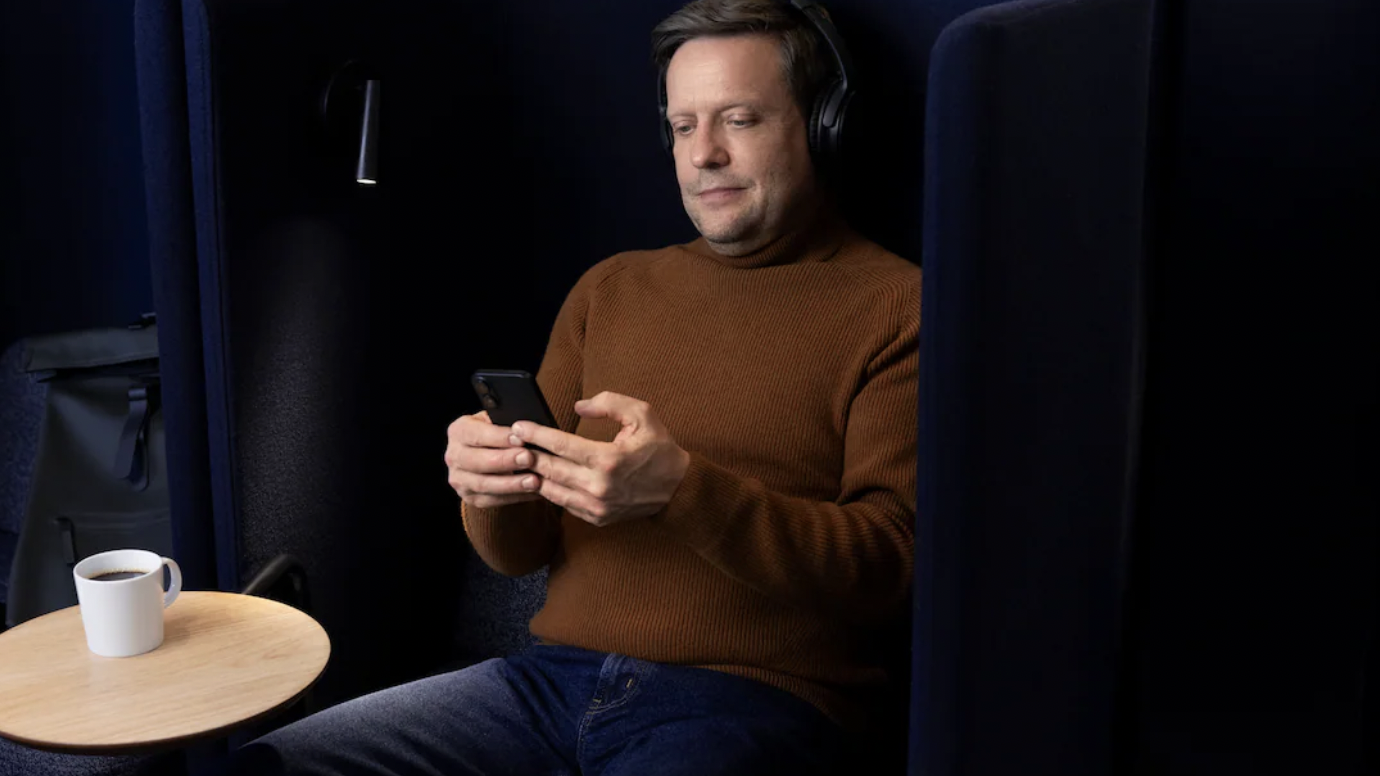 Man using smartphone in a quiet seating area