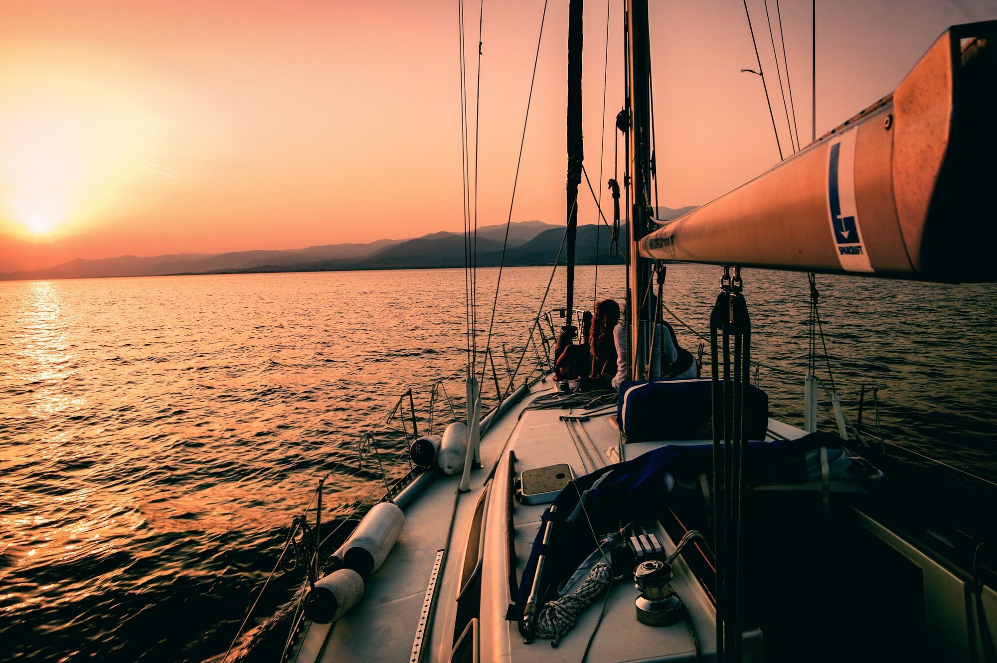 Sailing boat at sunset on open sea