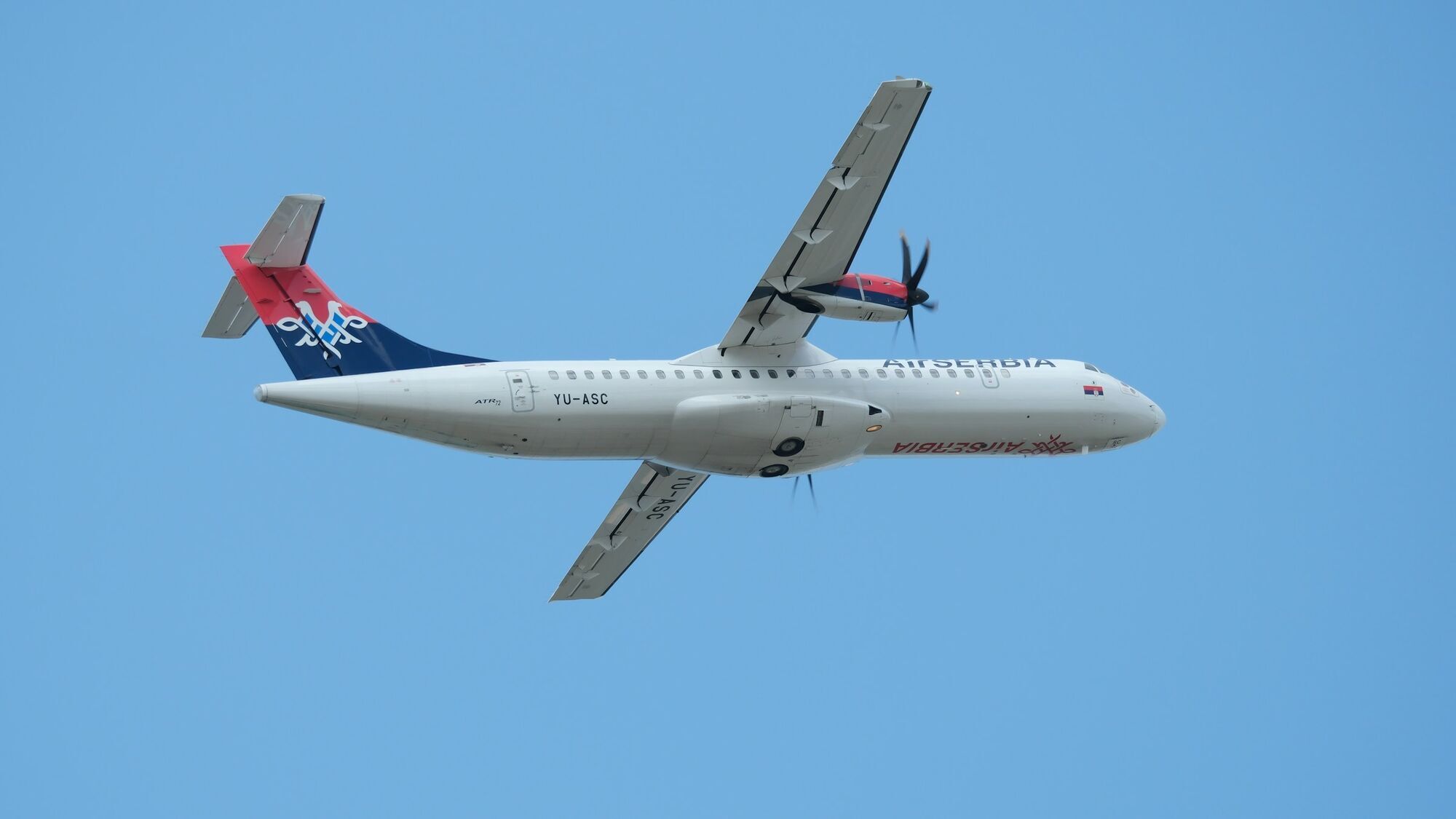 Air Serbia turboprop aircraft flying in clear sky