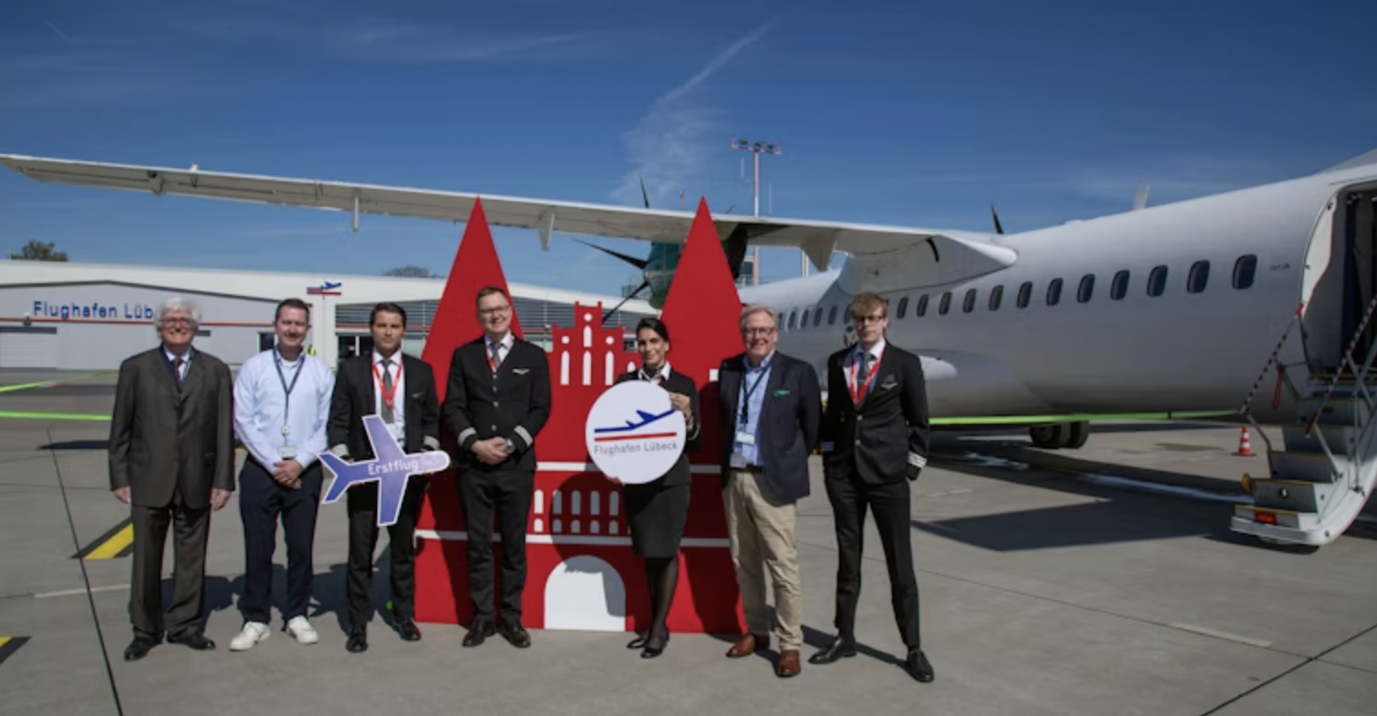 Group of staff standing near aircraft at Lübeck Airport