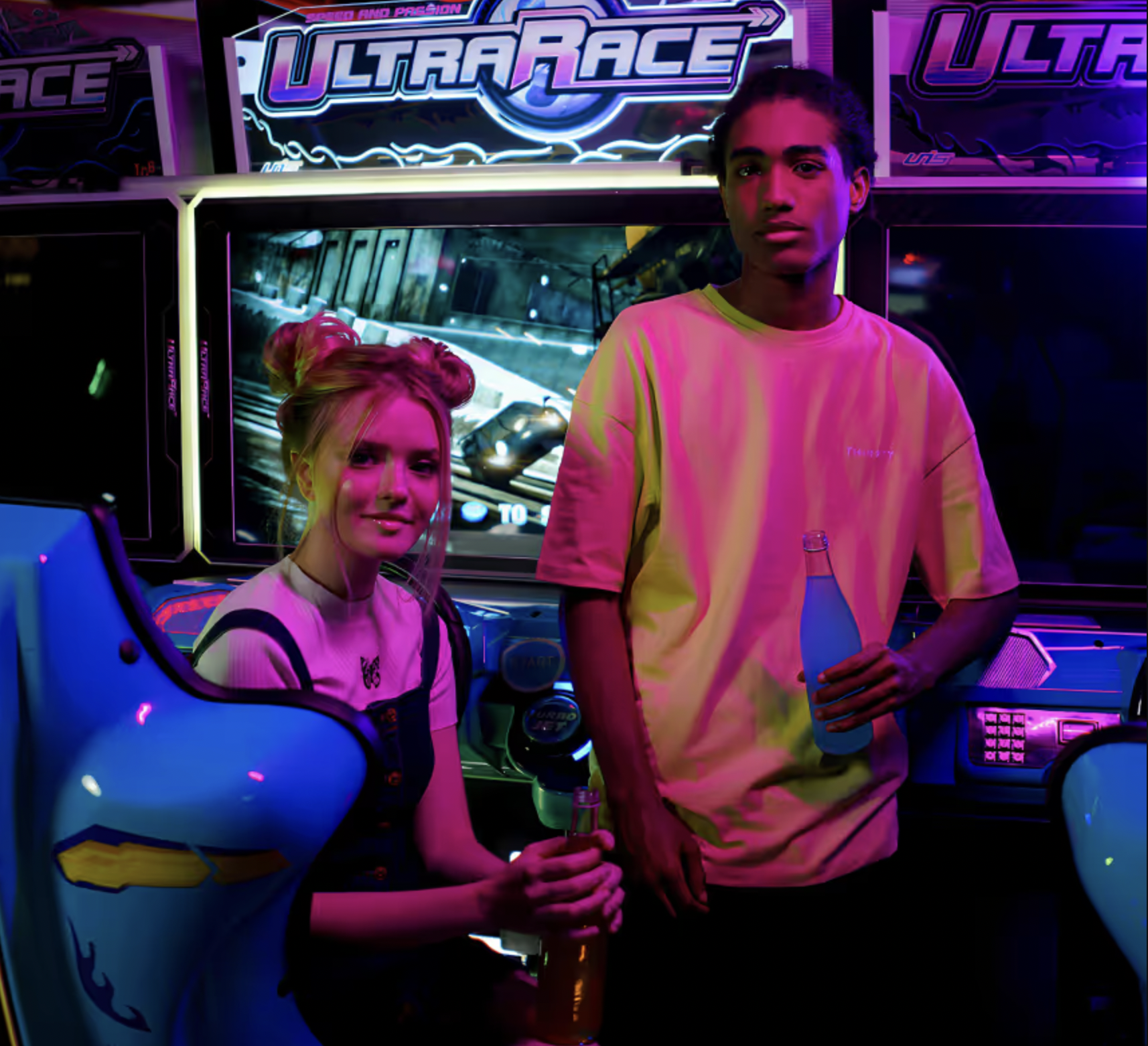 People playing arcade racing game in neon-lit entertainment venue