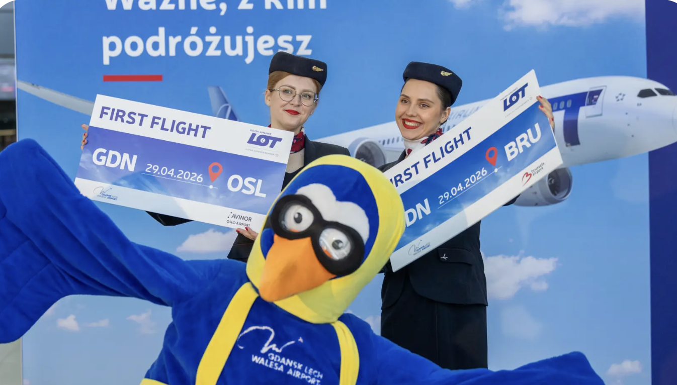 LOT crew holding first flight signs at Gdansk Airport