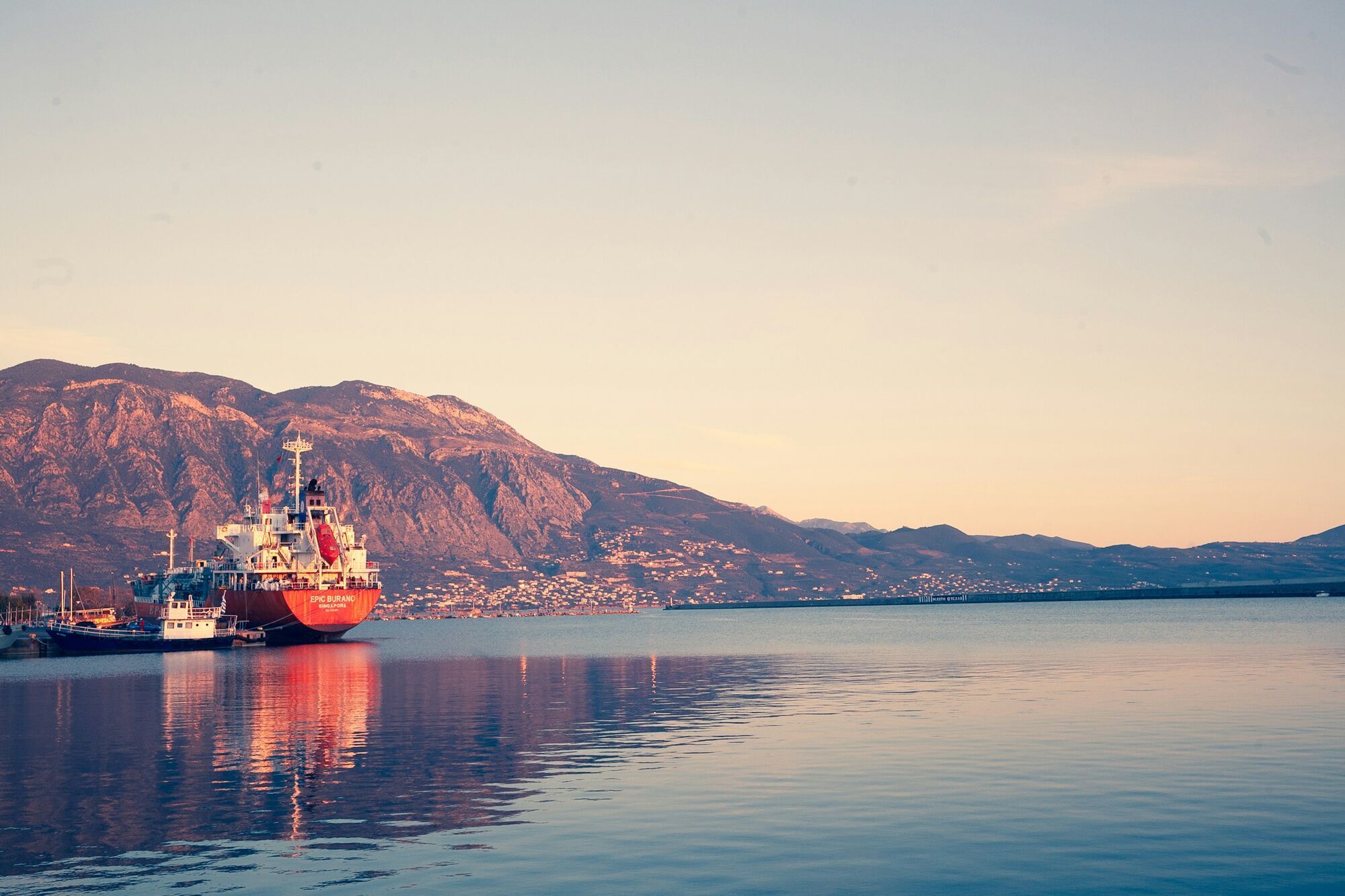 Cargo ship docked in Kalamata harbour with mountains in background