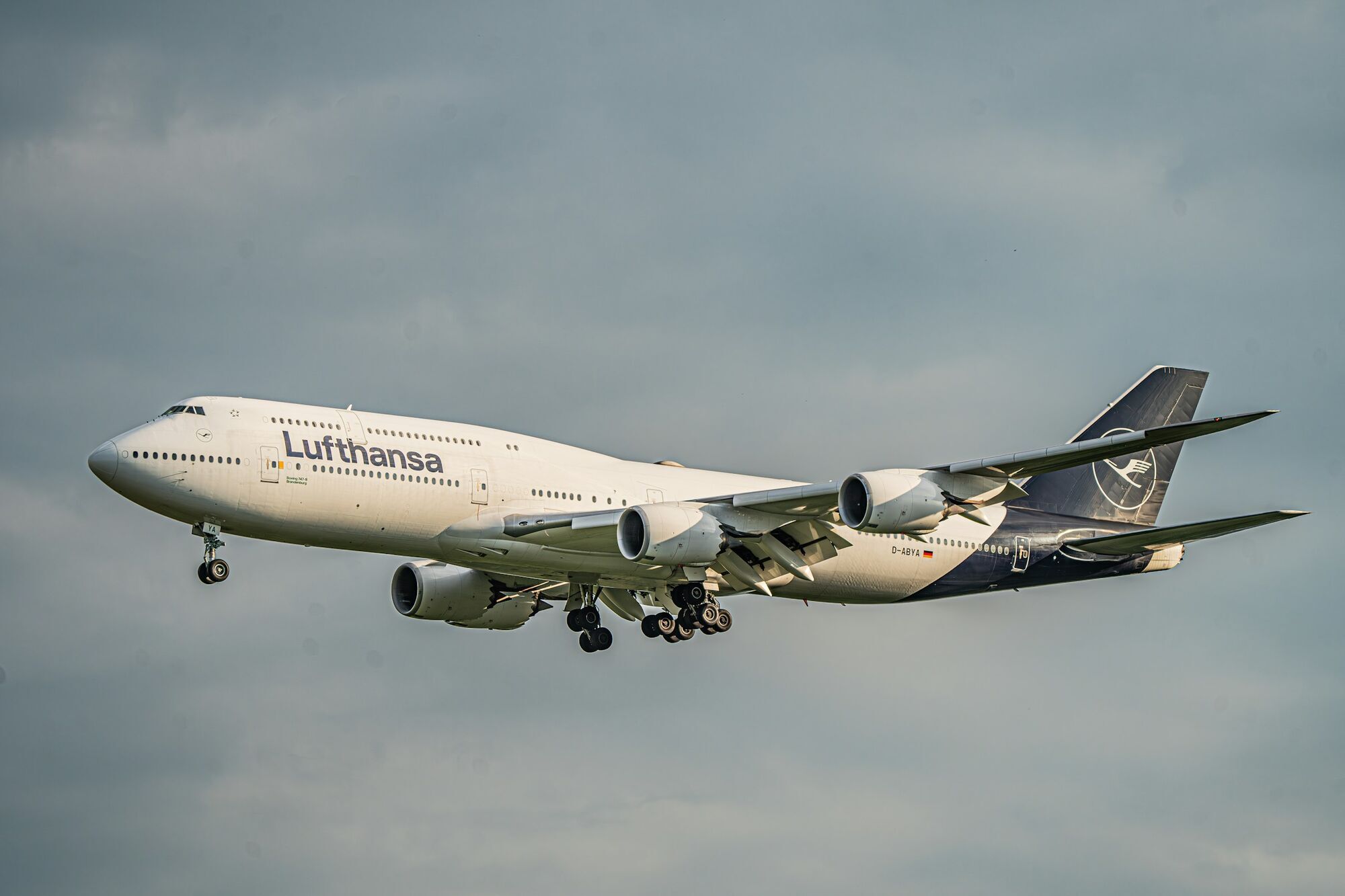 Lufthansa aircraft in flight against cloudy sky