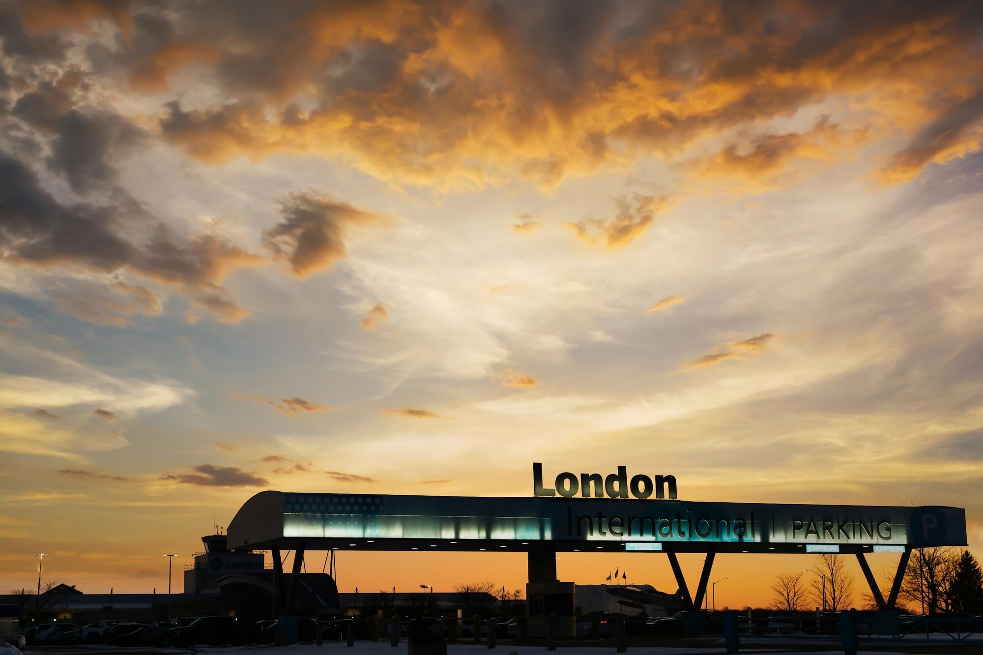 Airport parking entrance sign at sunset