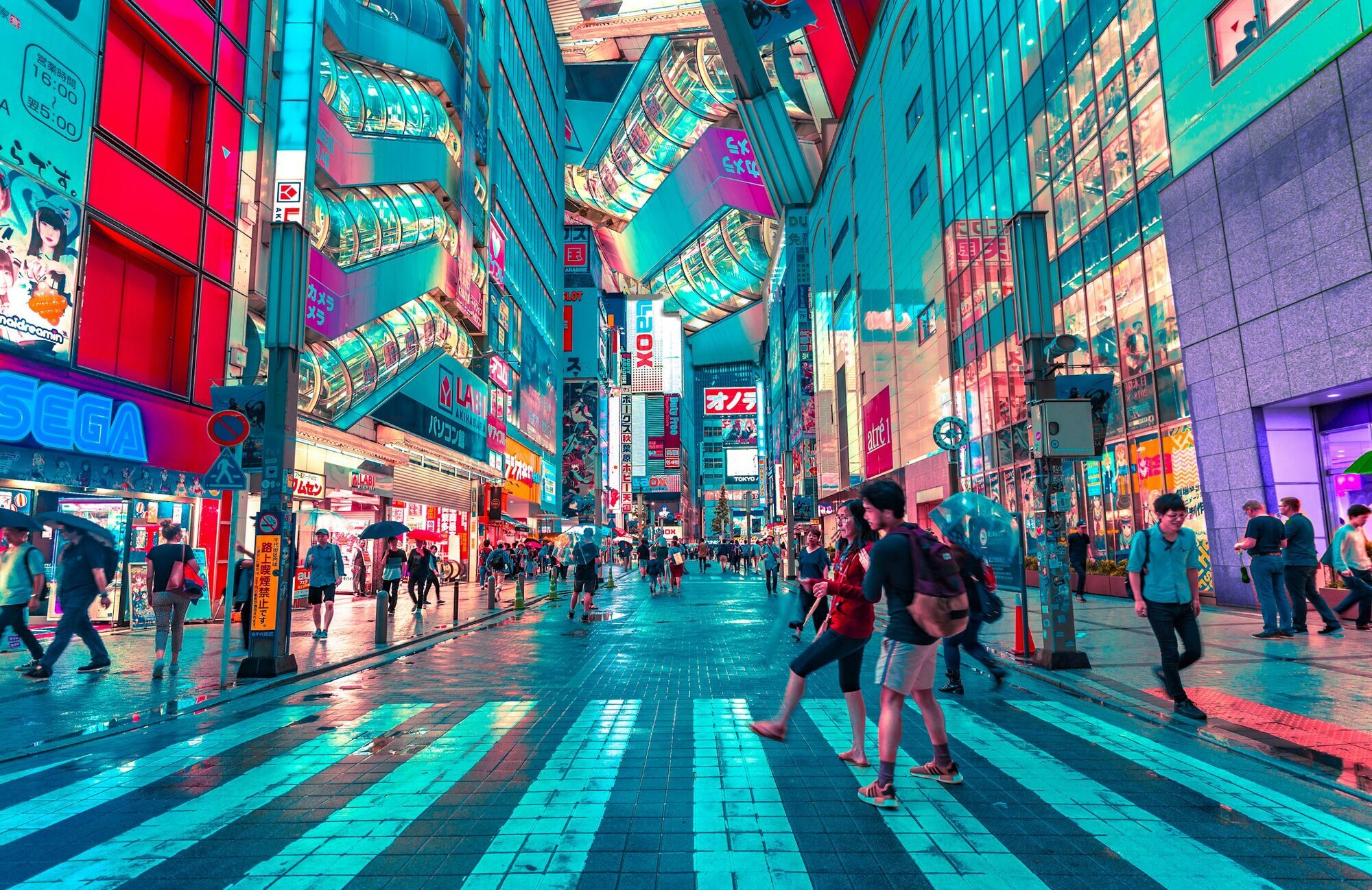 Pedestrians crossing busy street in central Tokyo at night