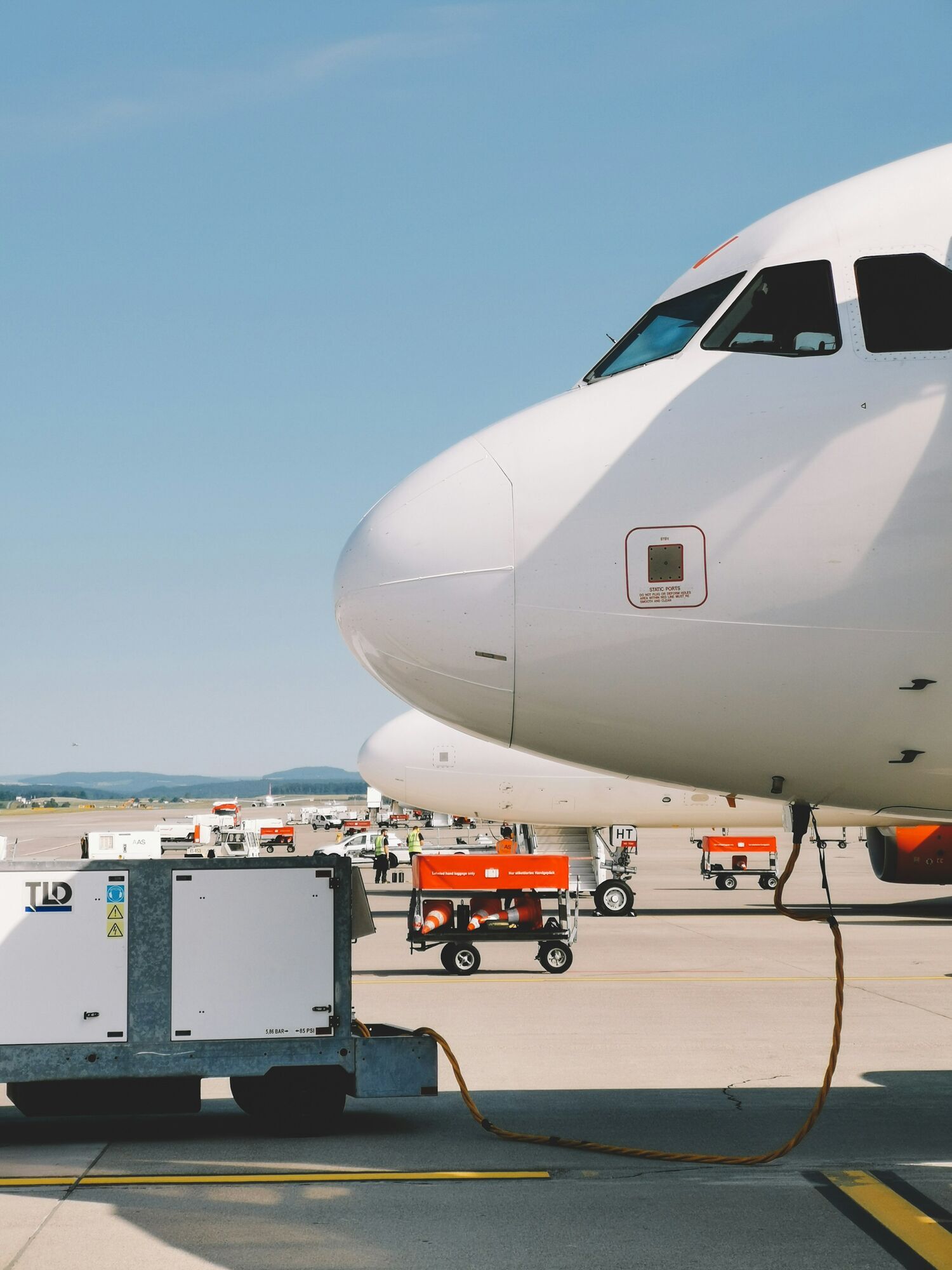 Aircraft on airport apron connected to ground equipment