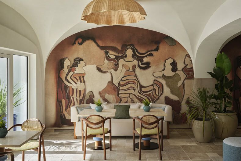Restaurant interior with mural artwork and seating area inside W Sardinia