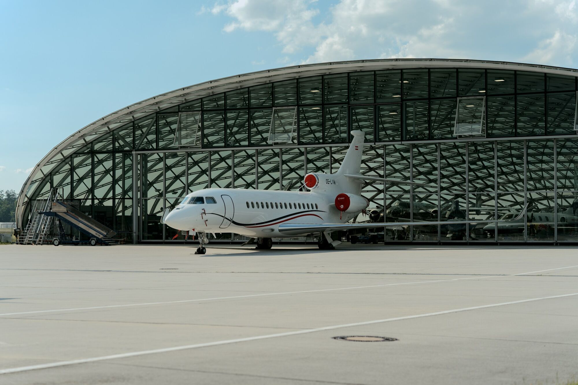 Private jet parked beside an airport hangar