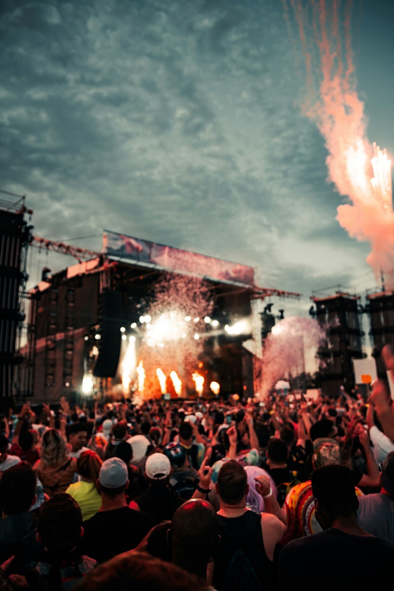 Crowd watching a festival stage with lights and smoke