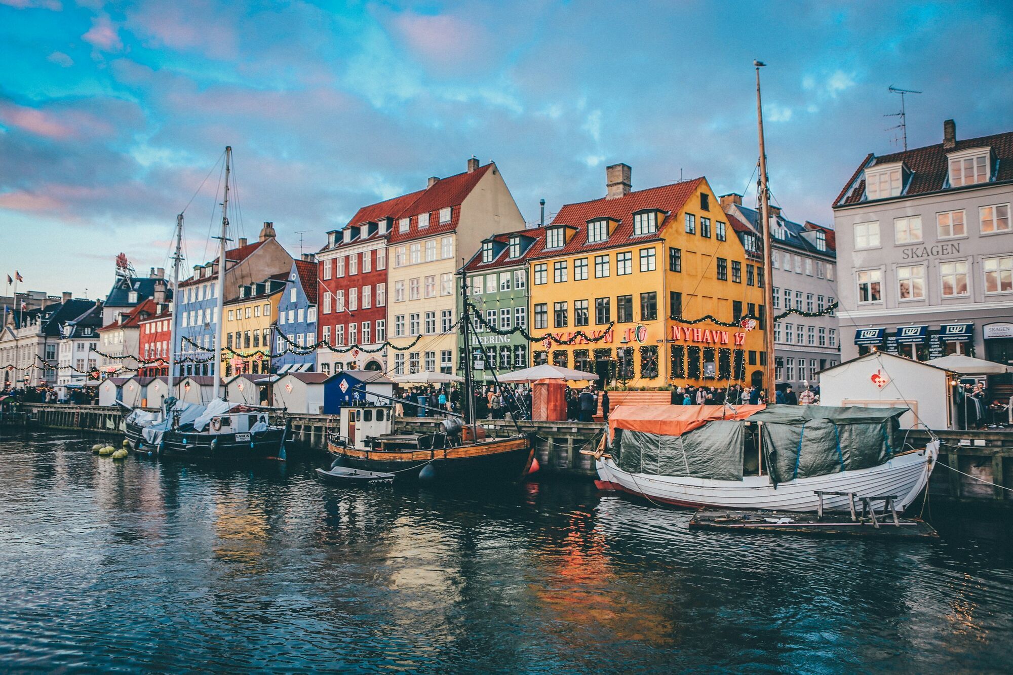 Colourful buildings and boats along Nyhavn harbour in Copenhagen