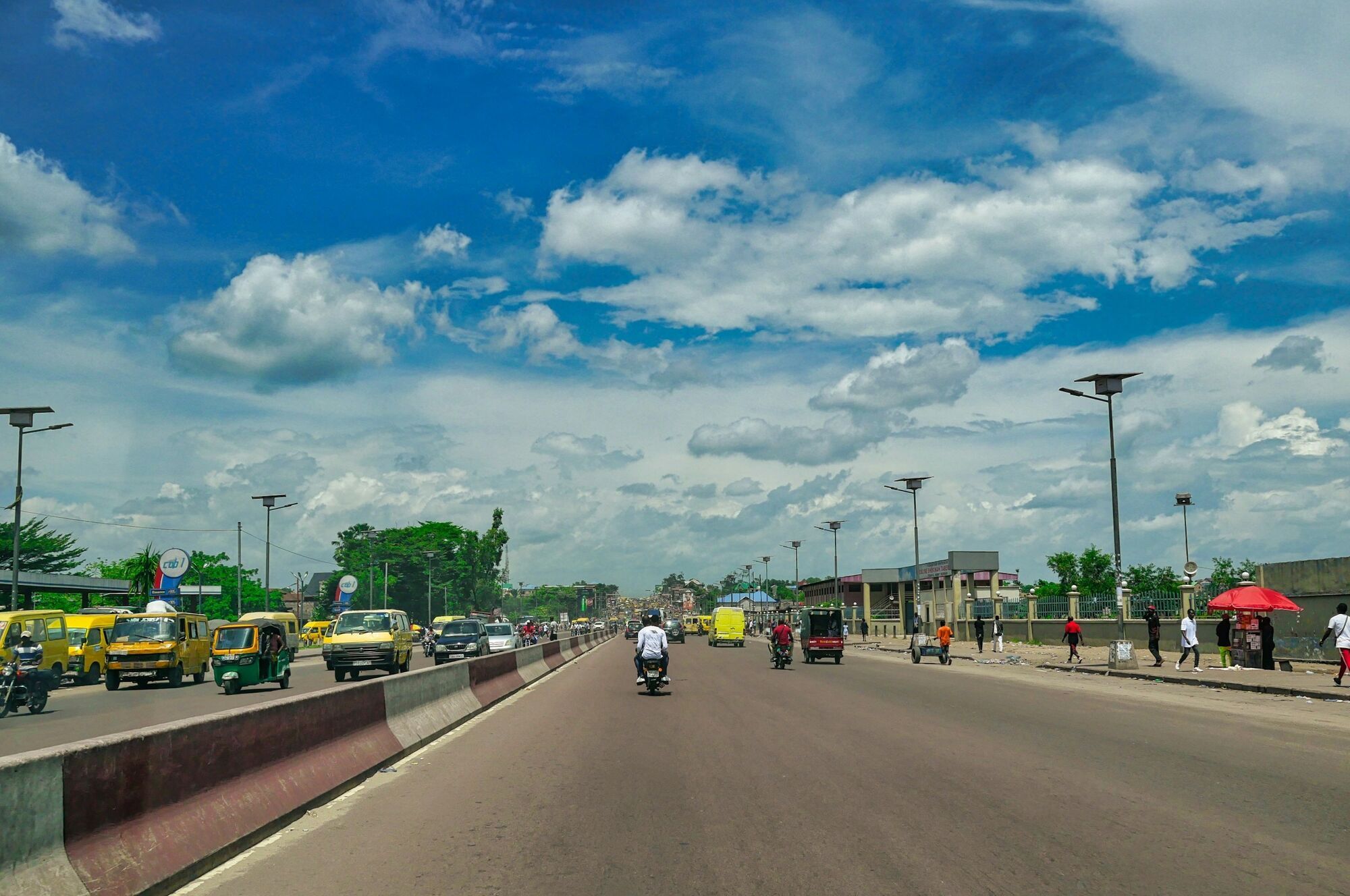 Wide road scene in Kinshasa under a cloudy sky