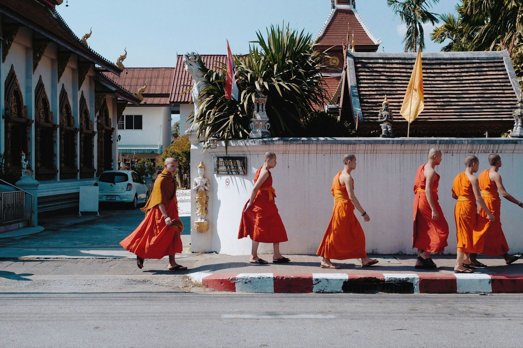 Buddhist monks walking past a temple in Thailand