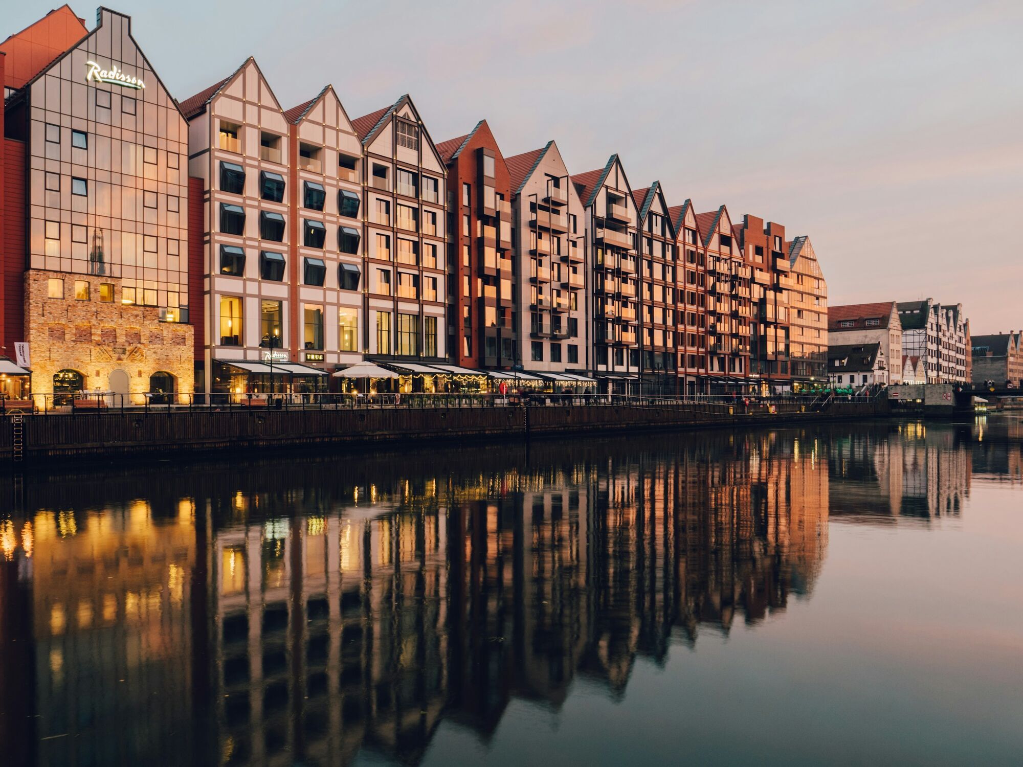 Gdańsk waterfront buildings reflected in the river at dusk