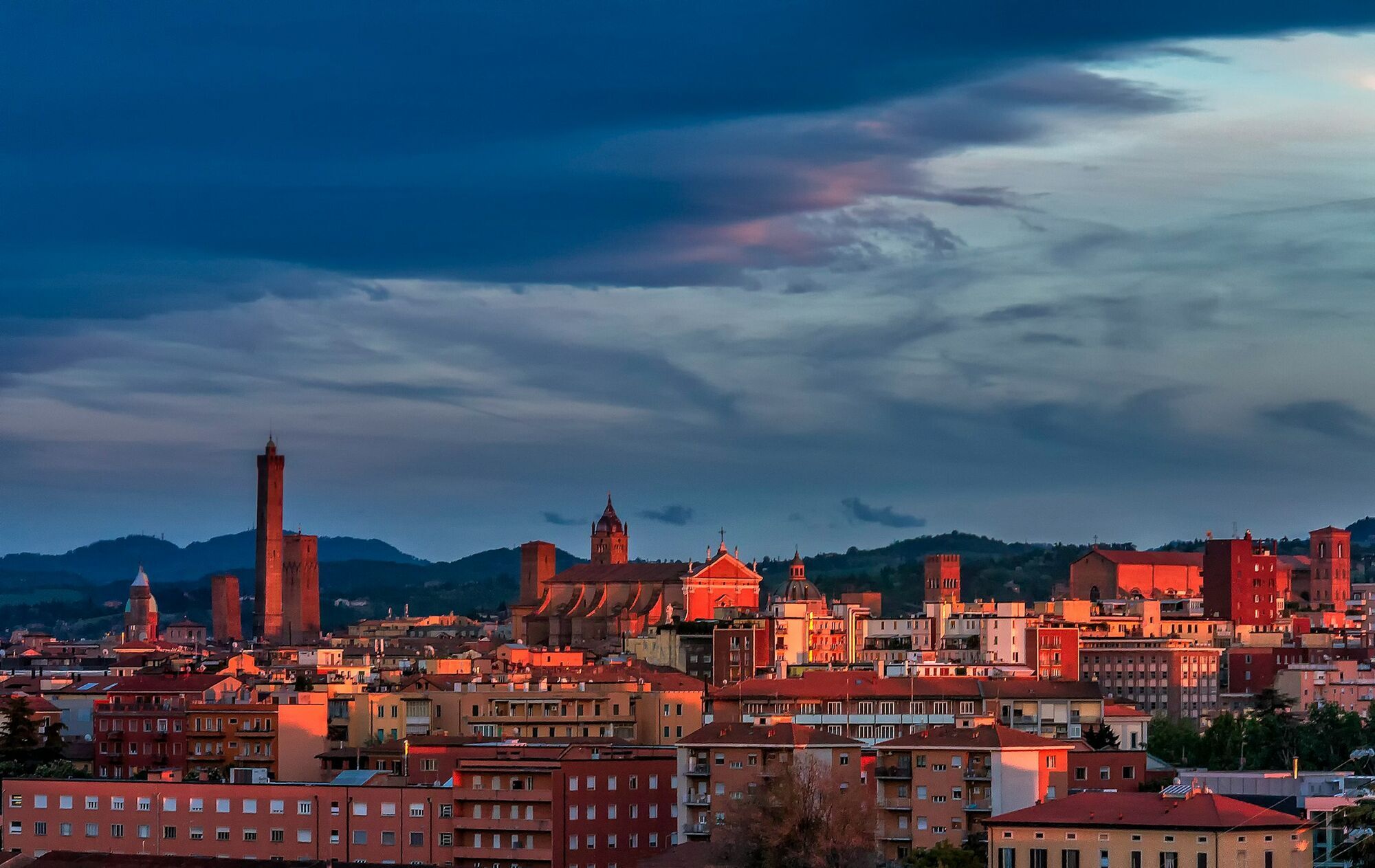 Bologna skyline under dark clouds at sunset