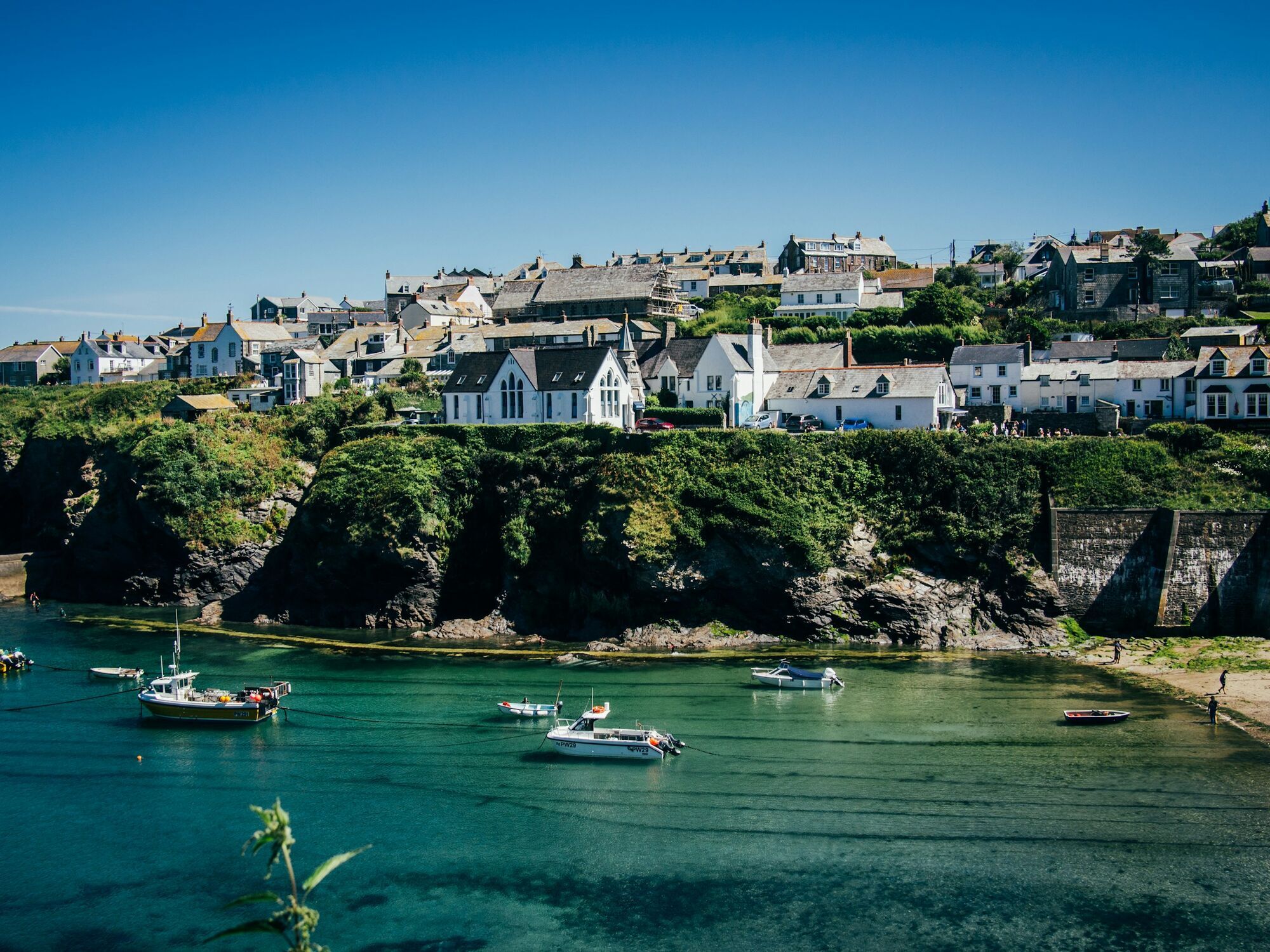 Harbour village with boats and white houses on the Cornish coast